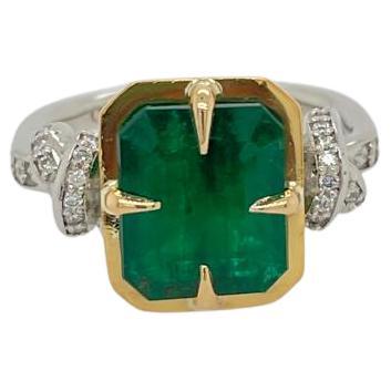 Glamorously bold and unabashedly seductive. This showstopper ring features an intense natural Emerald poised between sharp eagle style talons and embraced by powerful-platinum, diamond encrusted ropes, converging to two knots on either side of the