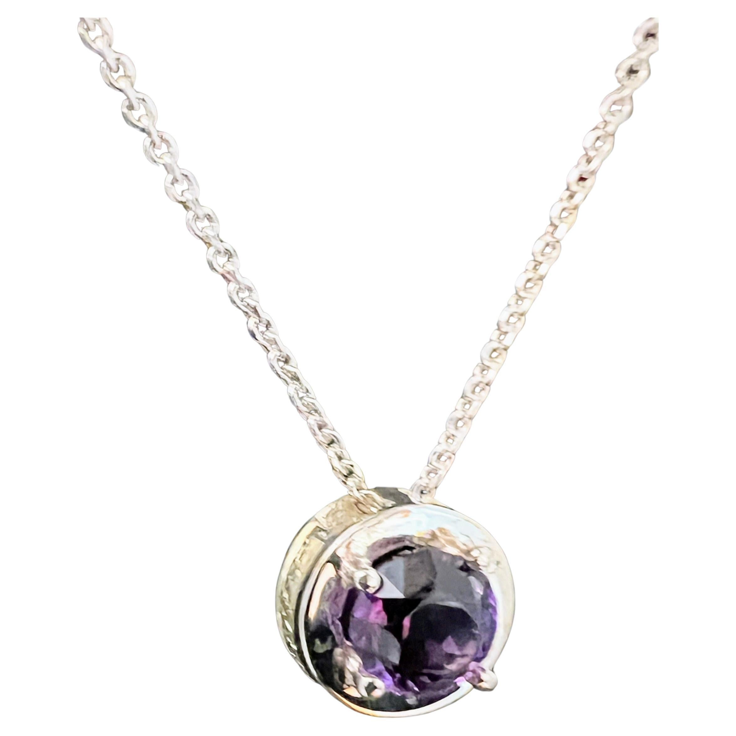 Questo ciondolo per collana è realizzato con un'attenzione meticolosa ai dettagli e presenta un'ametista naturale dal taglio rotondo di 7 mm, che si distingue per la sua profonda tonalità violacea e la sua brillante limpidezza. L'ametista è tenuta
