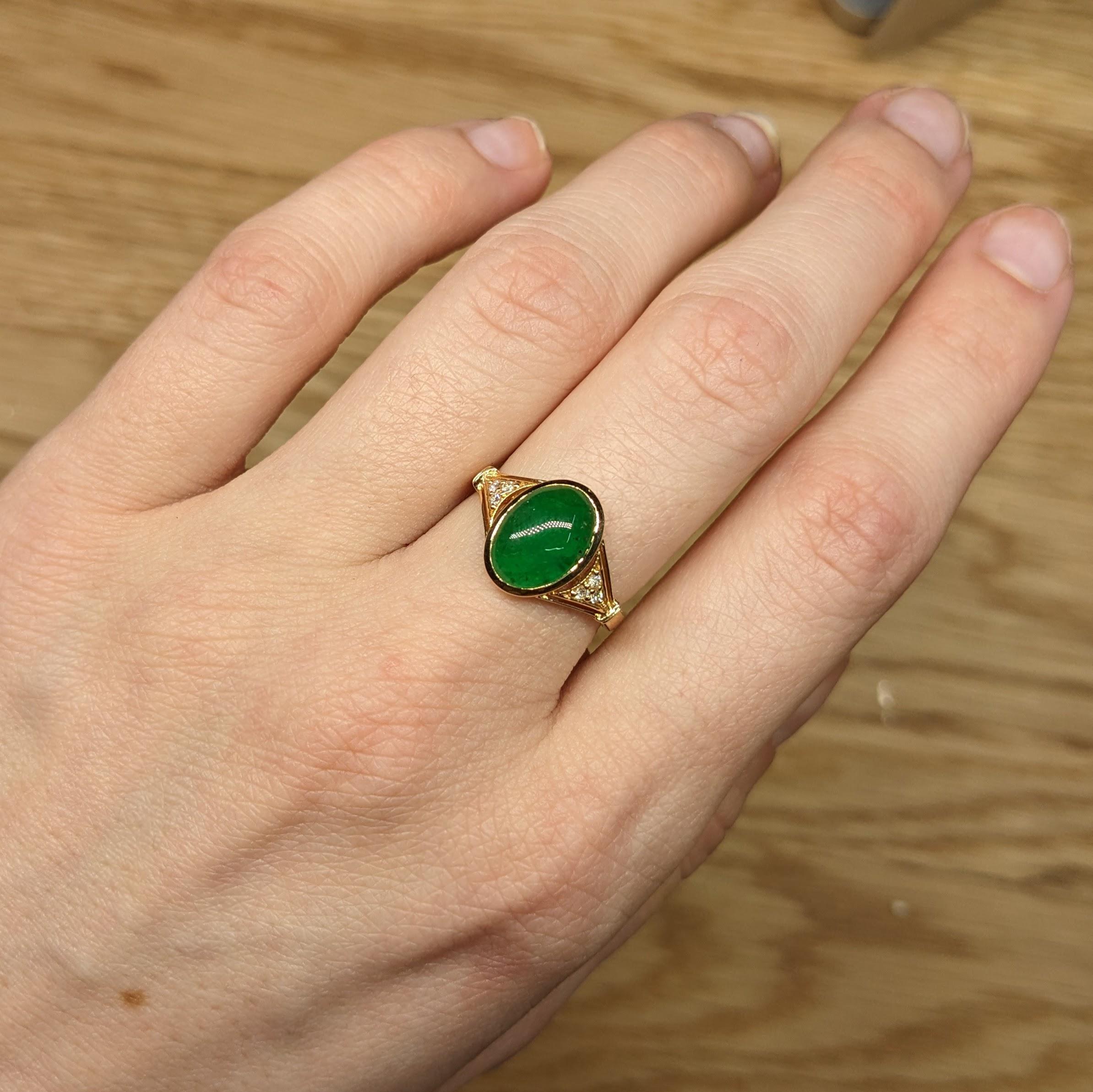A vivid oval 3 carat Emerald looks exquisite in this elegant ring with cute earth mined diamond accents in solid 14k gold. A statement ring design perfect for an eye catching engagement or anniversary. This ring also makes a beautiful May birthstone
