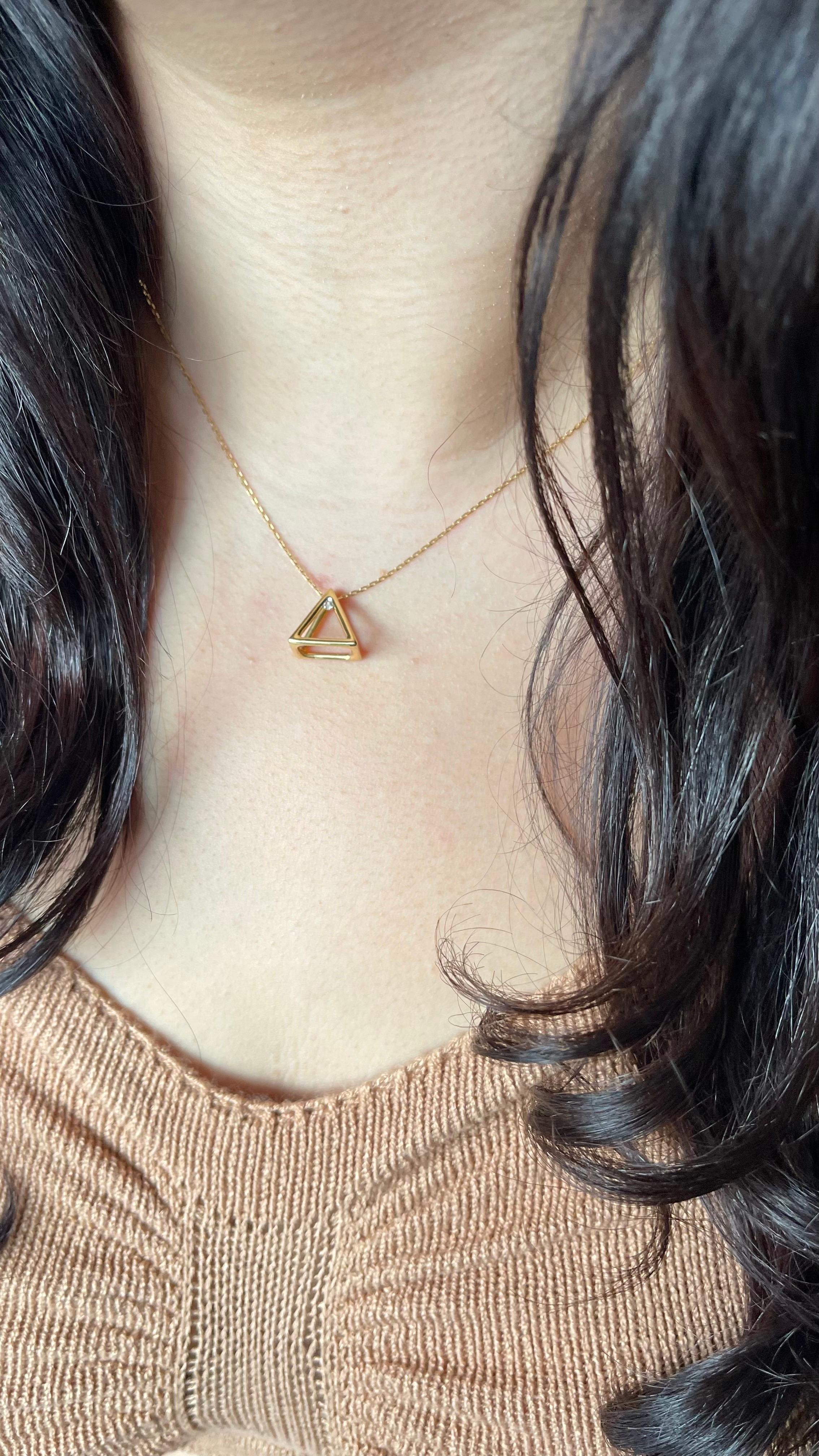 Ce collier remarquable présente un pendentif pyramidal tridimensionnel, réalisé avec précision en or jaune 18 carats. Le design pyramidal à cadre ouvert offre une esthétique moderne et minimaliste, ce qui en fait un accessoire polyvalent qui
