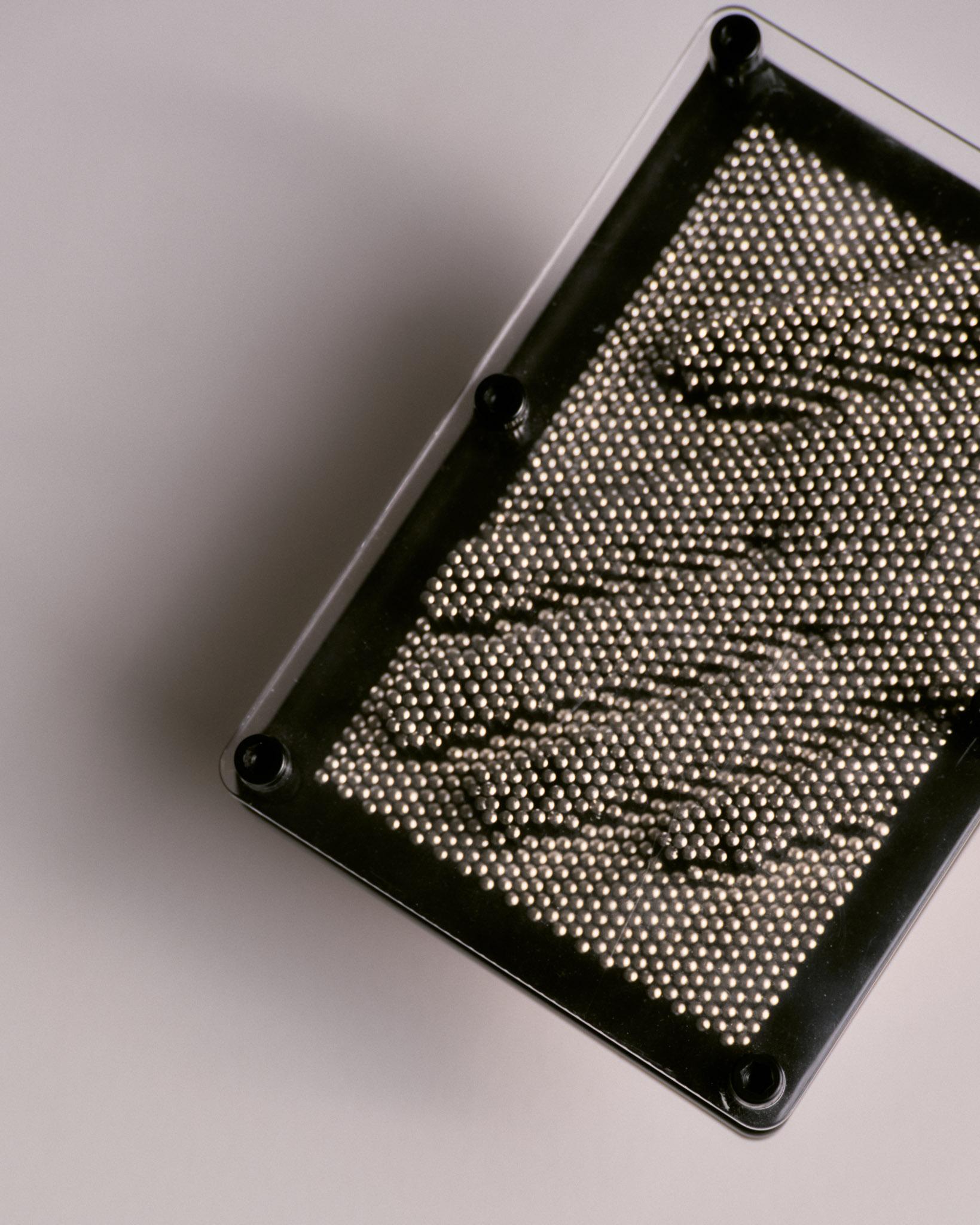 Spielerisches und dekoratives Objekt, das aus Tausenden von kleinen Metallstiften besteht, die durch einen transparenten Kunststoffrahmen gleiten. Ermöglicht die Erstellung dreidimensionaler Eindrücke von einem Objekt. 
