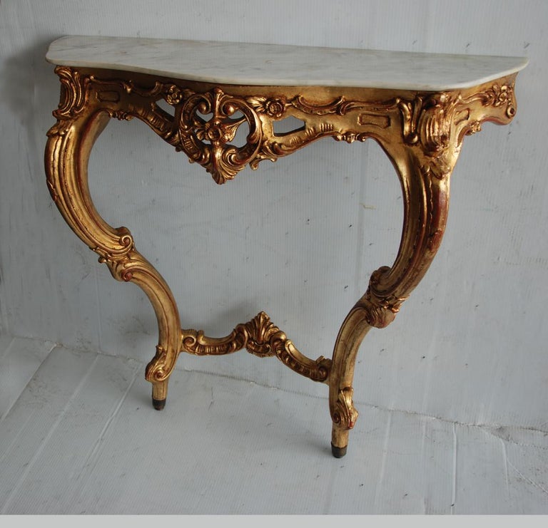 3ft 19th century Italian Rococo style wall mount giltwood console table
 
Italian Rococo-Revival style giltwood console with a marble top from the 19th century. Pierced and carved apron raised on carved cabriole legs.
 

 
  