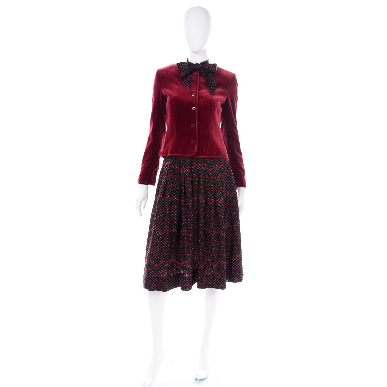 This is a beautifully made Jaeger 3 piece outfit in rich Autumnal/Winter hues. We love the deep red velvet jacket and the gorgeous print of the blouse and skirt. 
The fully lined  jacket has buttons down the center front opening and a collarless