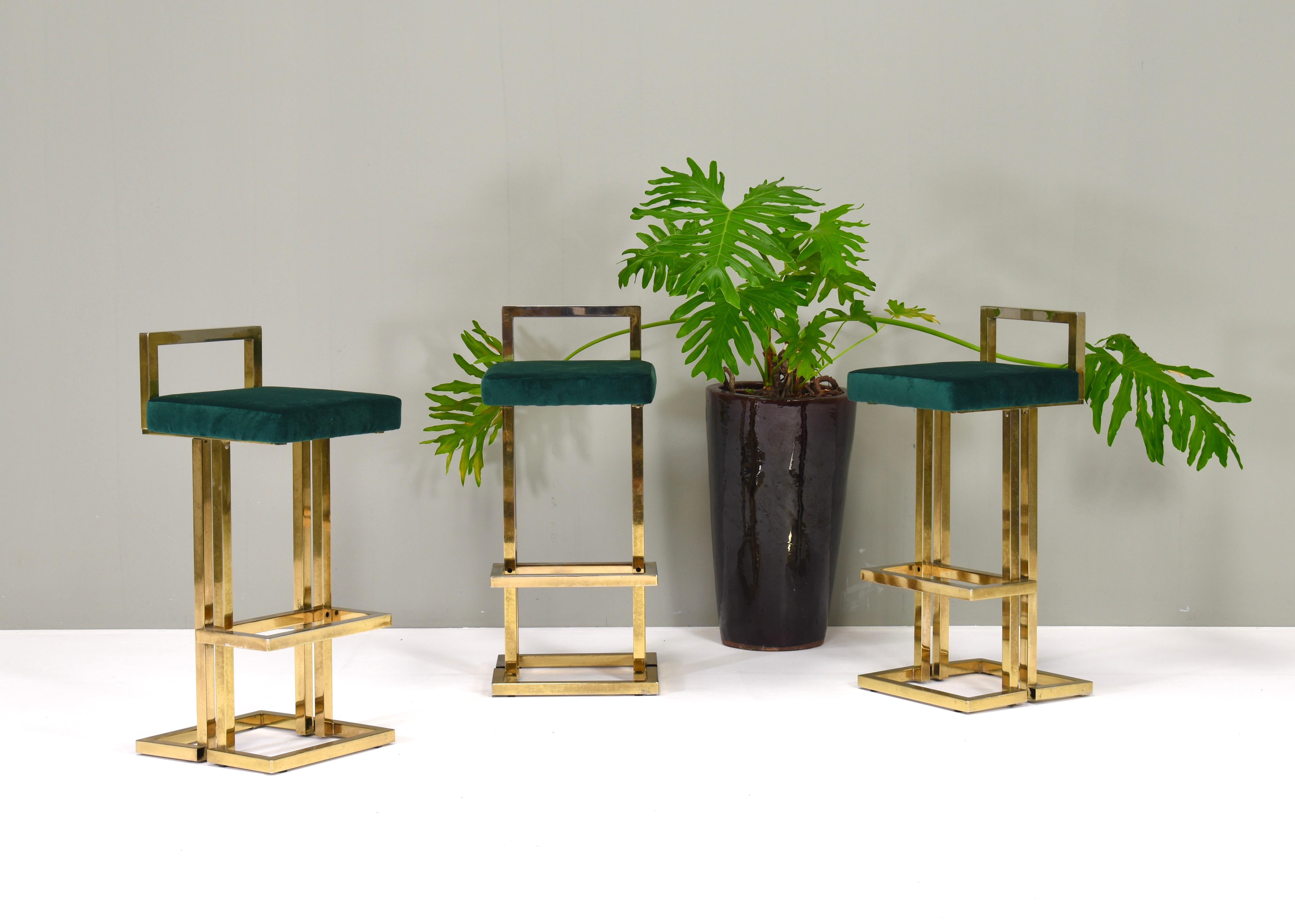Set of three Hollywood Regency bar stools in brass and green velvet by Maison Jansen.
The seats have been reupholstered with new foam and green velvet fabric. The brass has a worn and faded patina. The structure still remains strong with repairs or