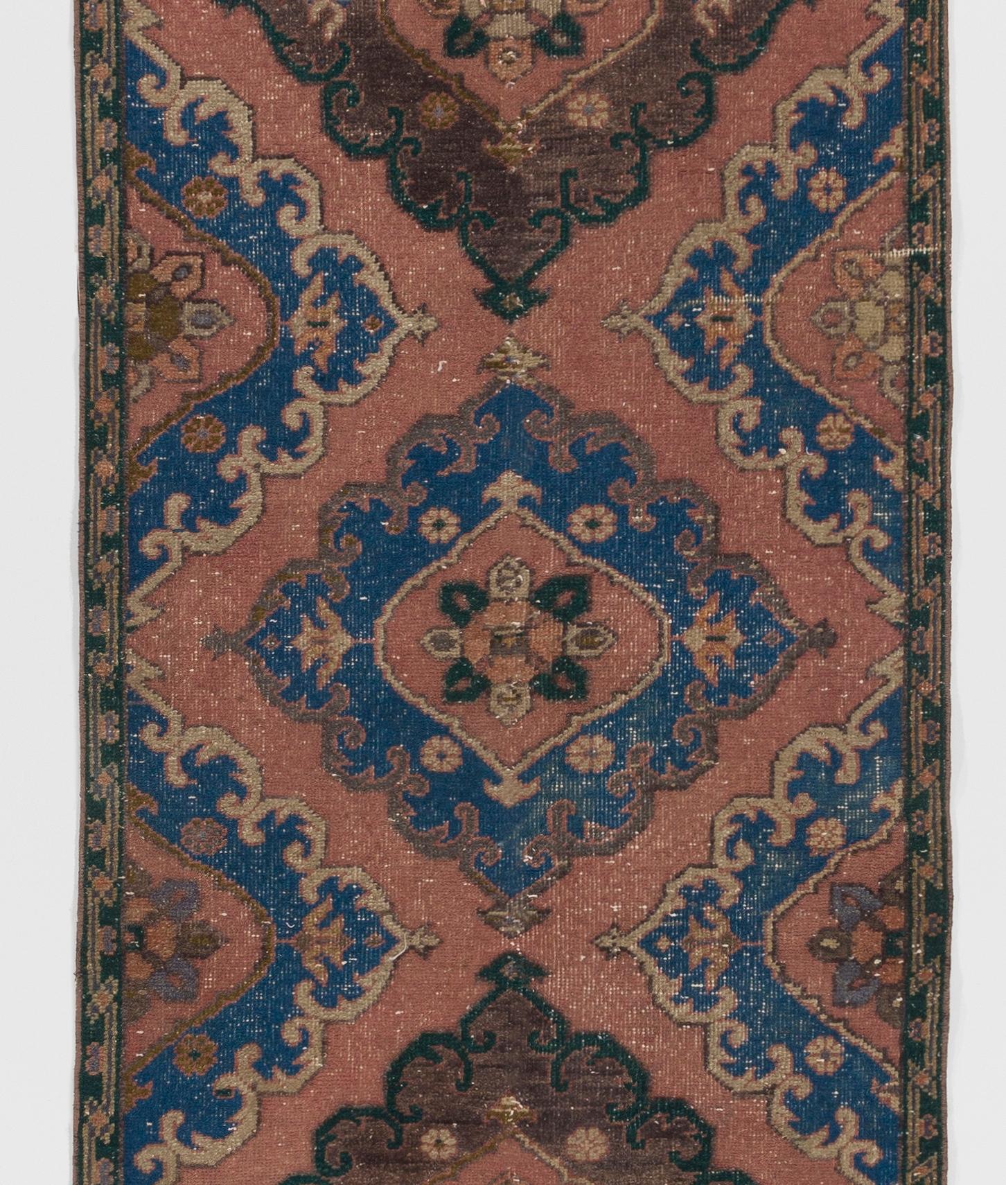 A mid-20th century hand knotted runner rug from Central Anatolia. 

As a true vintage piece, this runner rug has aged gracefully, acquiring a patina that enhances its character and authenticity. The all-wool composition contributes to a luxurious