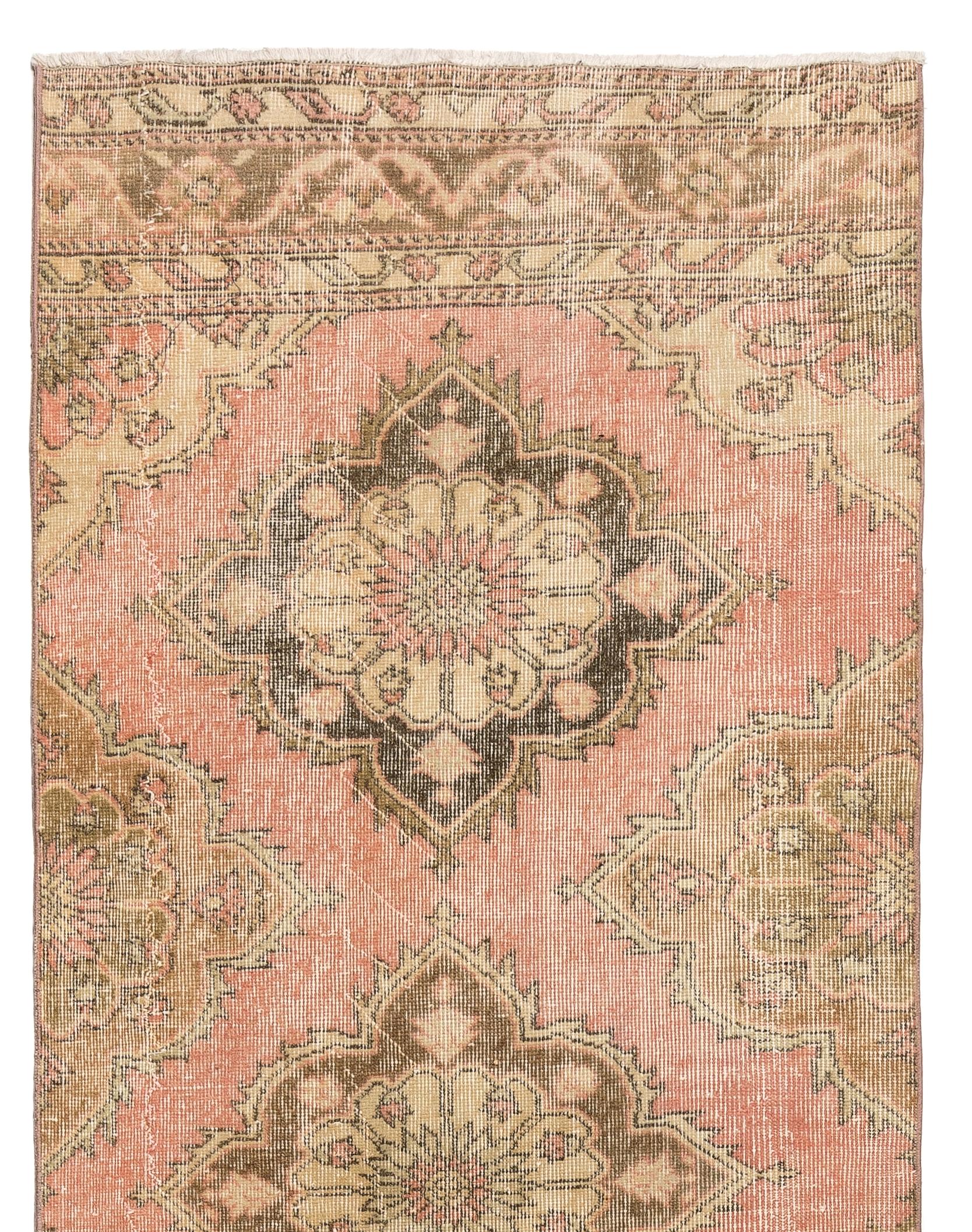 A vintage Turkish runner rug in soft colors. It was hand-knotted in the 1960s with low wool on cotton foundation and features a multiple medallion design. It is in very good condition, professionally-washed, sturdy and suitable for areas with high