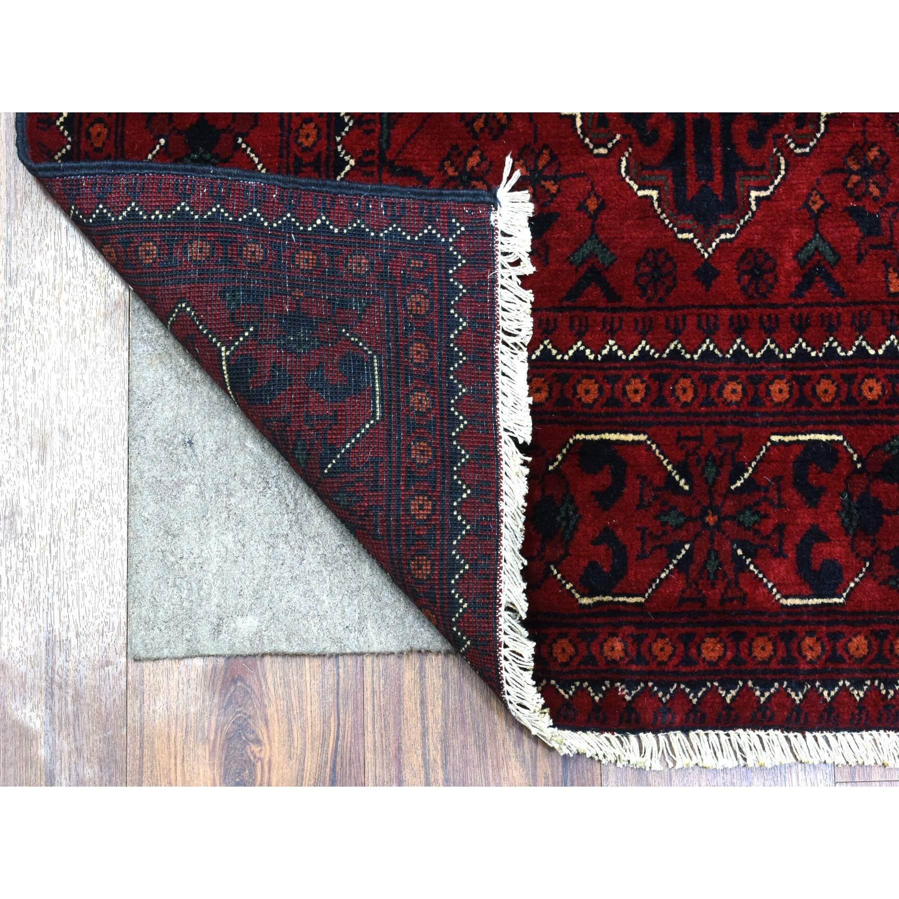 Il s'agit d'un véritable tapis de course en laine afghane Khamyab nouée à la main, au design géométrique rouge, unique en son genre. Il a été noué pendant des mois et des mois selon des techniques de tissage séculaires par des artisans