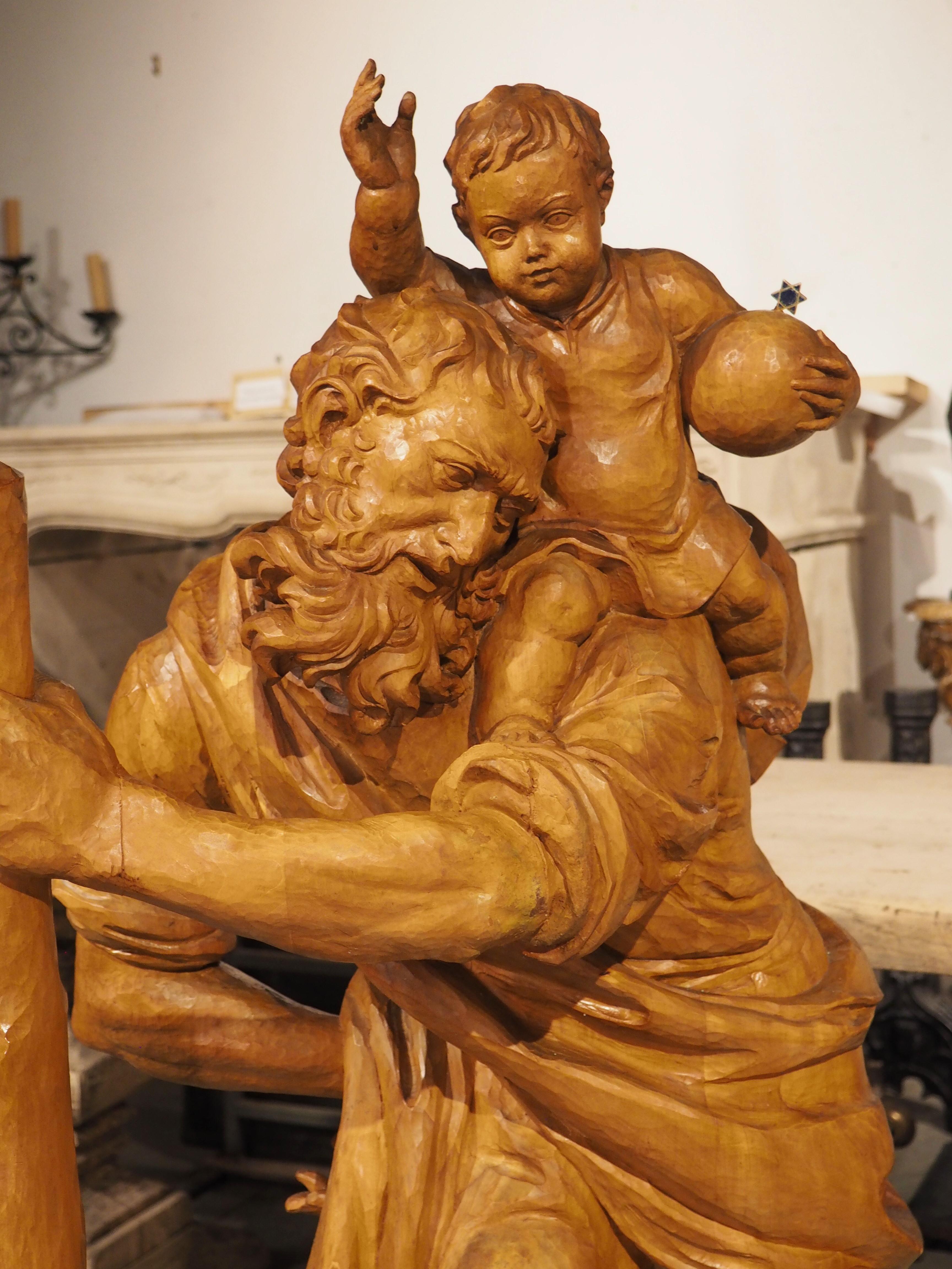 Hand-carved from limewood in Germany, circa 1930, this four-and-a-half-foot tall statue depicts St Christopher carrying a young Jesus across a river. The legend states that Christopher (who was considered to have size and strength), was instructed