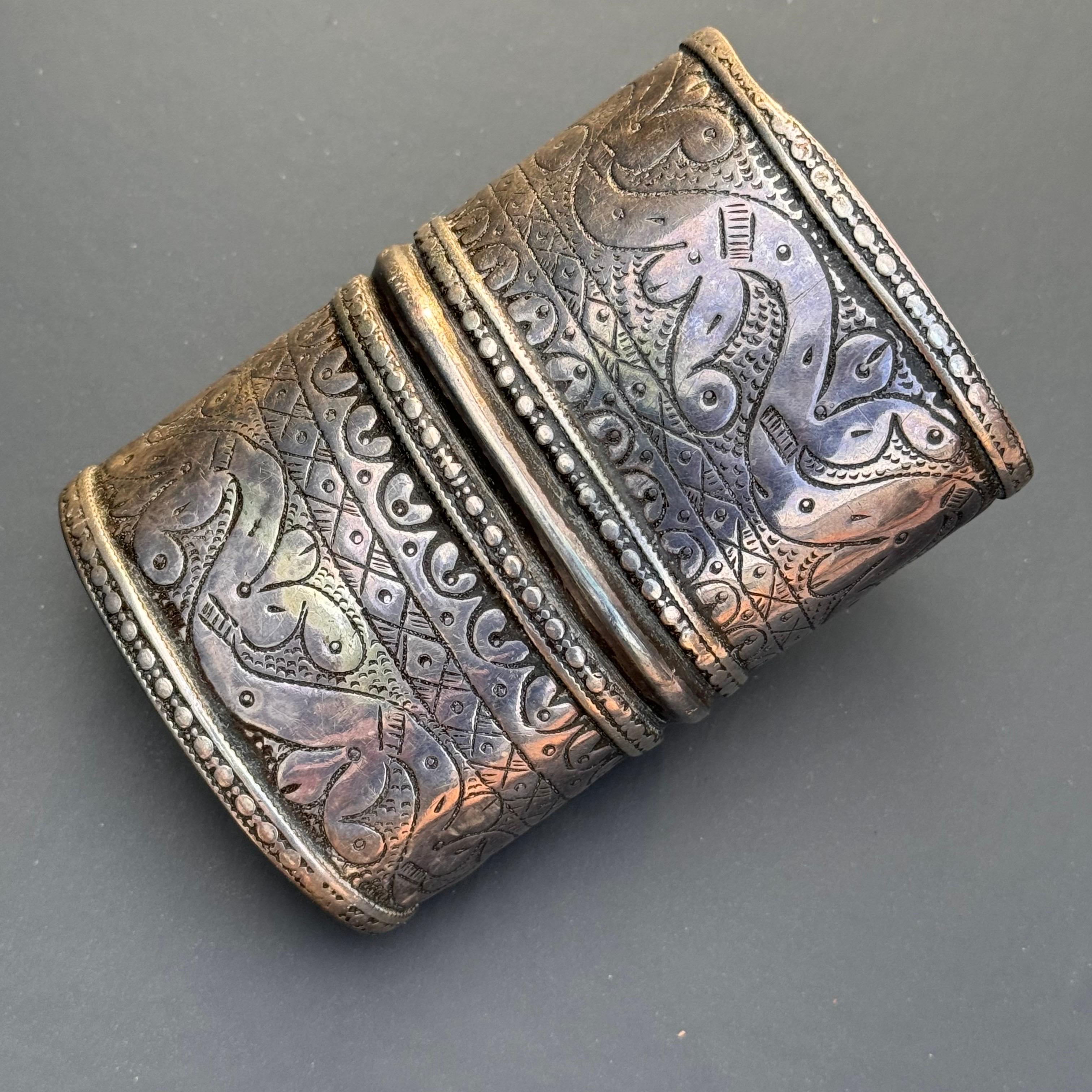 Abbraccia la bellezza senza tempo di questo bracciale largo, un pezzo straordinario che richiama il ricco patrimonio di Tunisia, Egitto e Libia. Con il suo squisito design cesellato a mano, questo braccialetto è una vera e propria opera d'arte, che