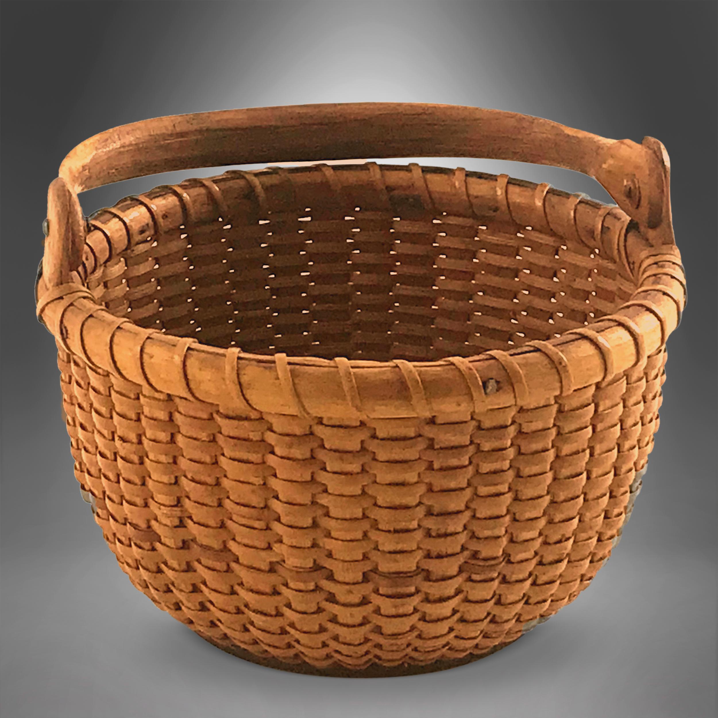 A small Nantucket lightship gathering basket
with sturdy wooden ears, and a convex interior
bottom with thee concentric lines typical of a
George Washington Ray (1814-1891) made basket,
circa 1870-1880. Measures: 4 ¾”.