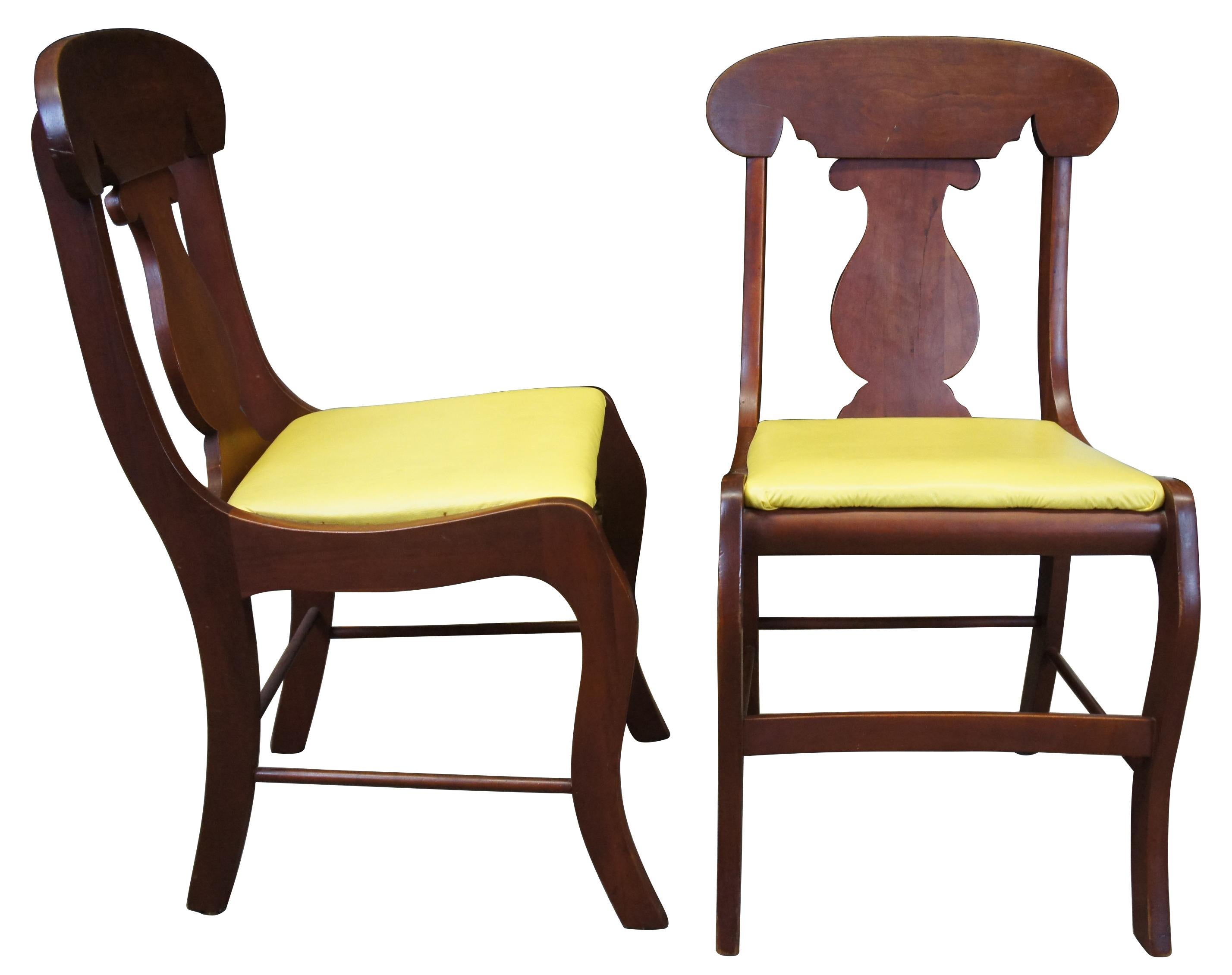 4 American Empire style dining chairs by The Sampler. The Sampler, out of Homer Indiana, has been making fine cherry furniture since 1946. Each of the four chairs is made from solid cherry, with a curved back rail over vase shaped splat and yellow