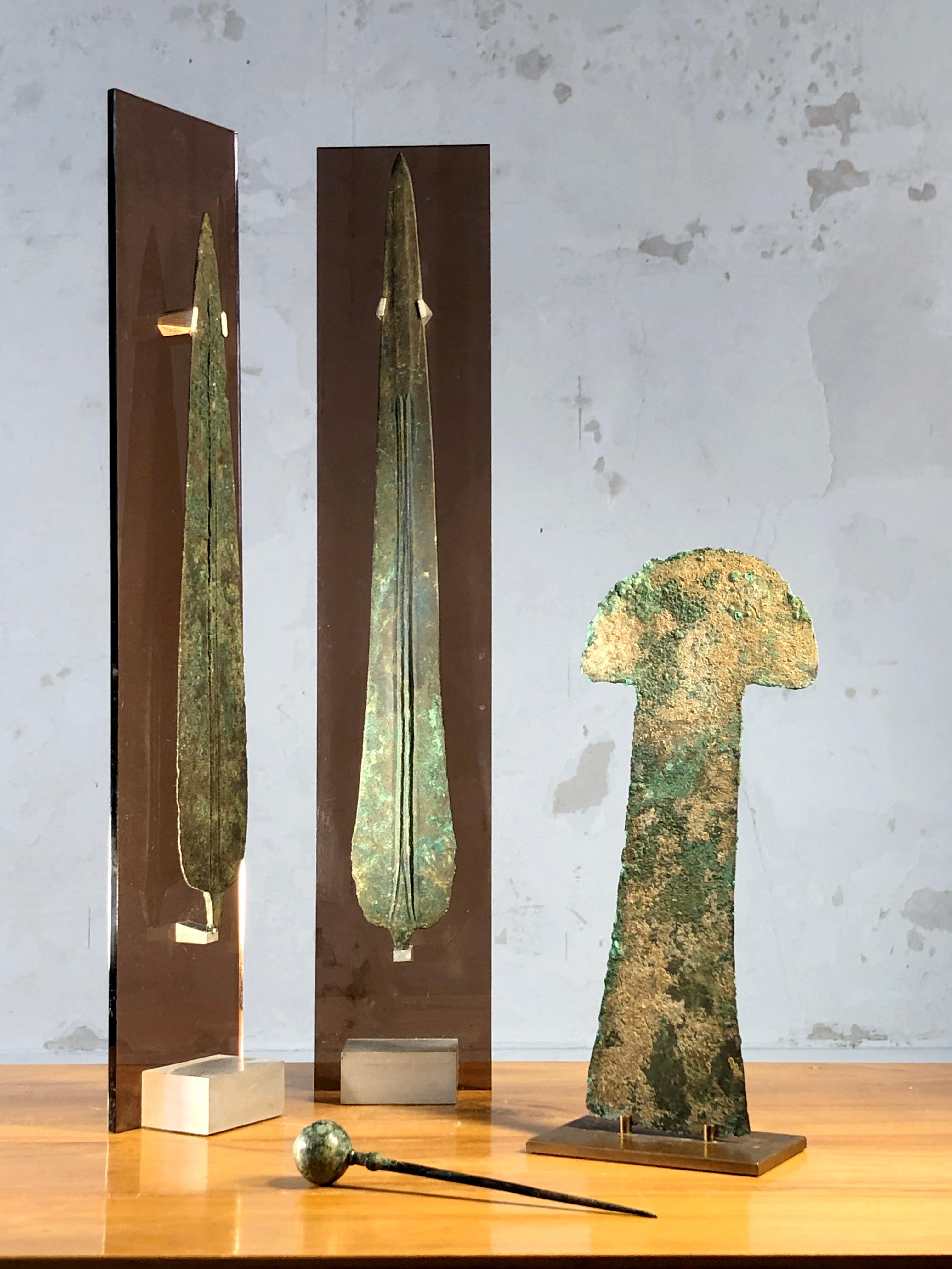 An exceptional set of 4 archaeological pieces and their 3 custom-made bases, Post-Modernist, Neo-Classical, Antique, Brutalist, Shabby-Chic, i.e. 2 large spears, 1 fibula and 1 sharp piece to be determined, all in superbly patinated bronze, and 3