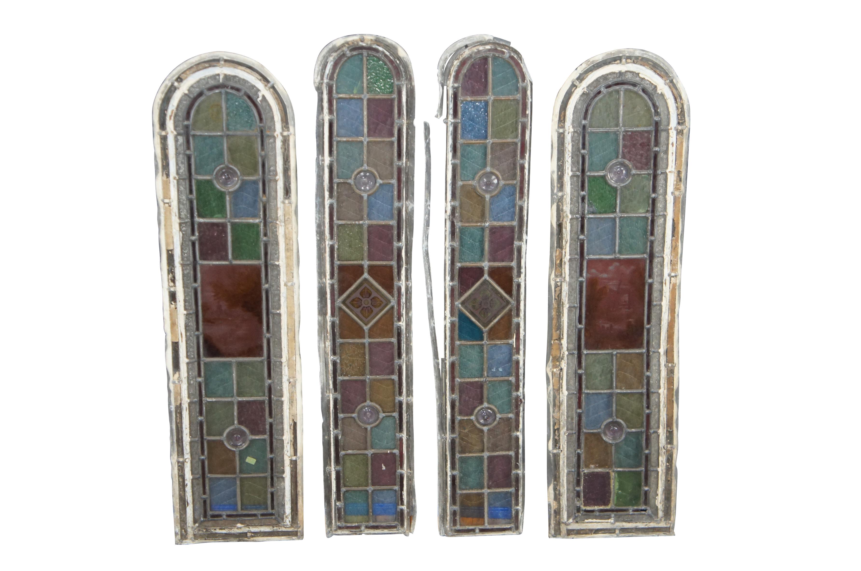 A charming set of four Early 1900s Edwardian reclaimed, leaded hand painted stained glass windows.  Features a multicolored geometric glass pattern set around hand painted and fired scenes and floral detail. the two larger windows showcase landscape