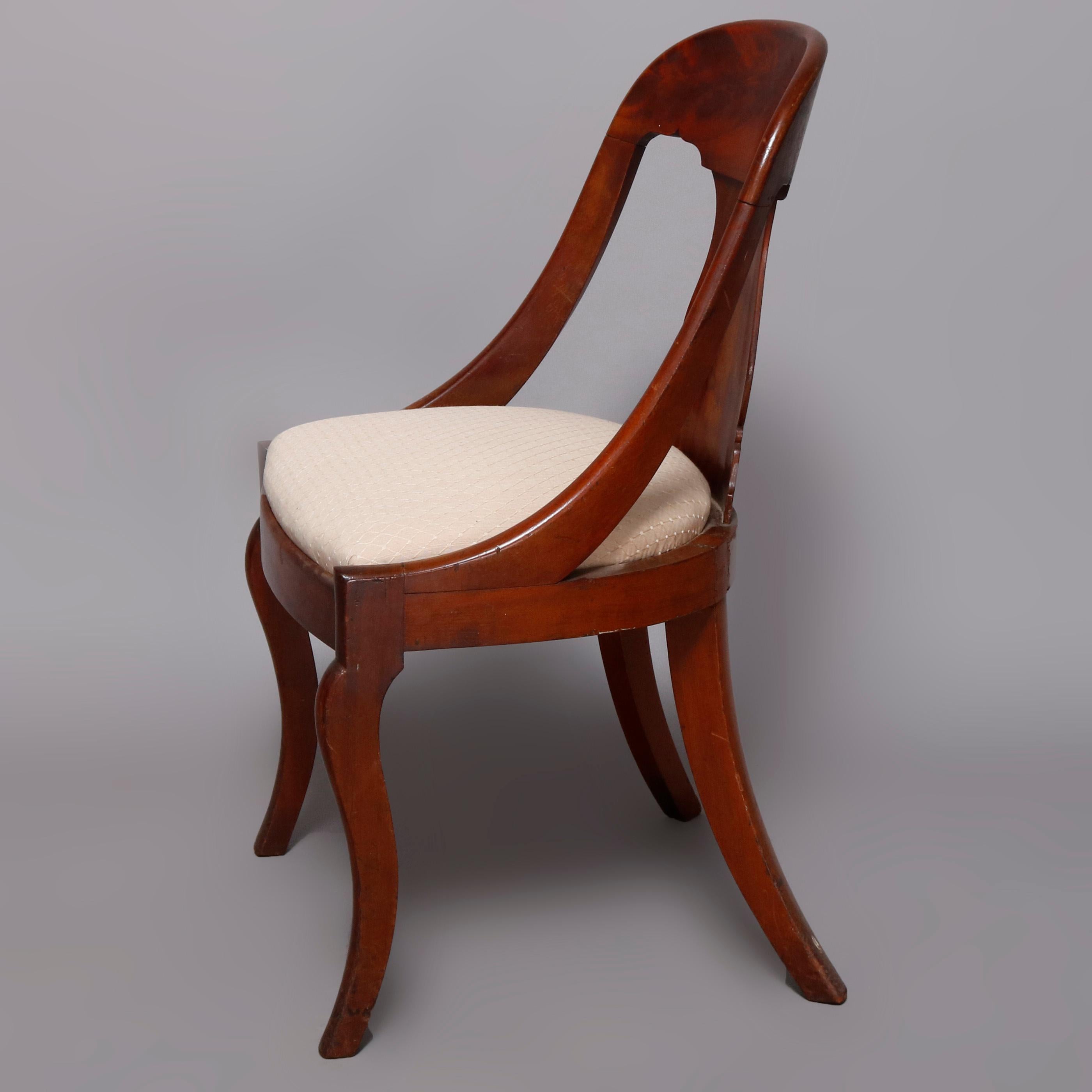 A set of four antique French Empire gondola chairs offer flame mahogany construction with bowed backs having urn form splats surmounting upholstered seats and raised on cabriole front legs, circa 1840.

Measures: 32.25