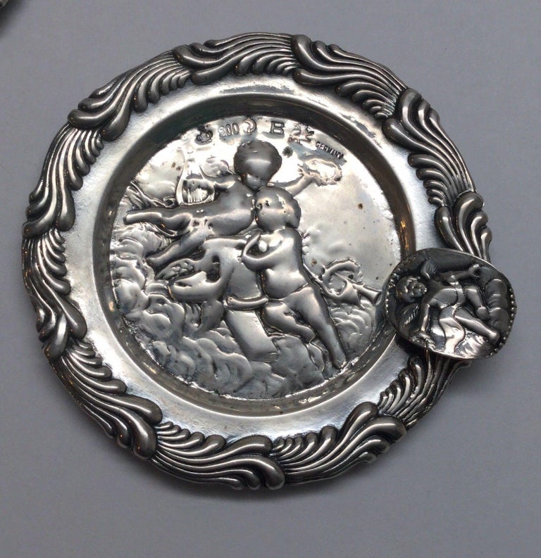 4 antique German 800 silver round ashtrays with cherub or putti motif. 
All marked: crown, 800, sickle in round cartouche, B, lion rampart, GERMANY. 
Measures: 3