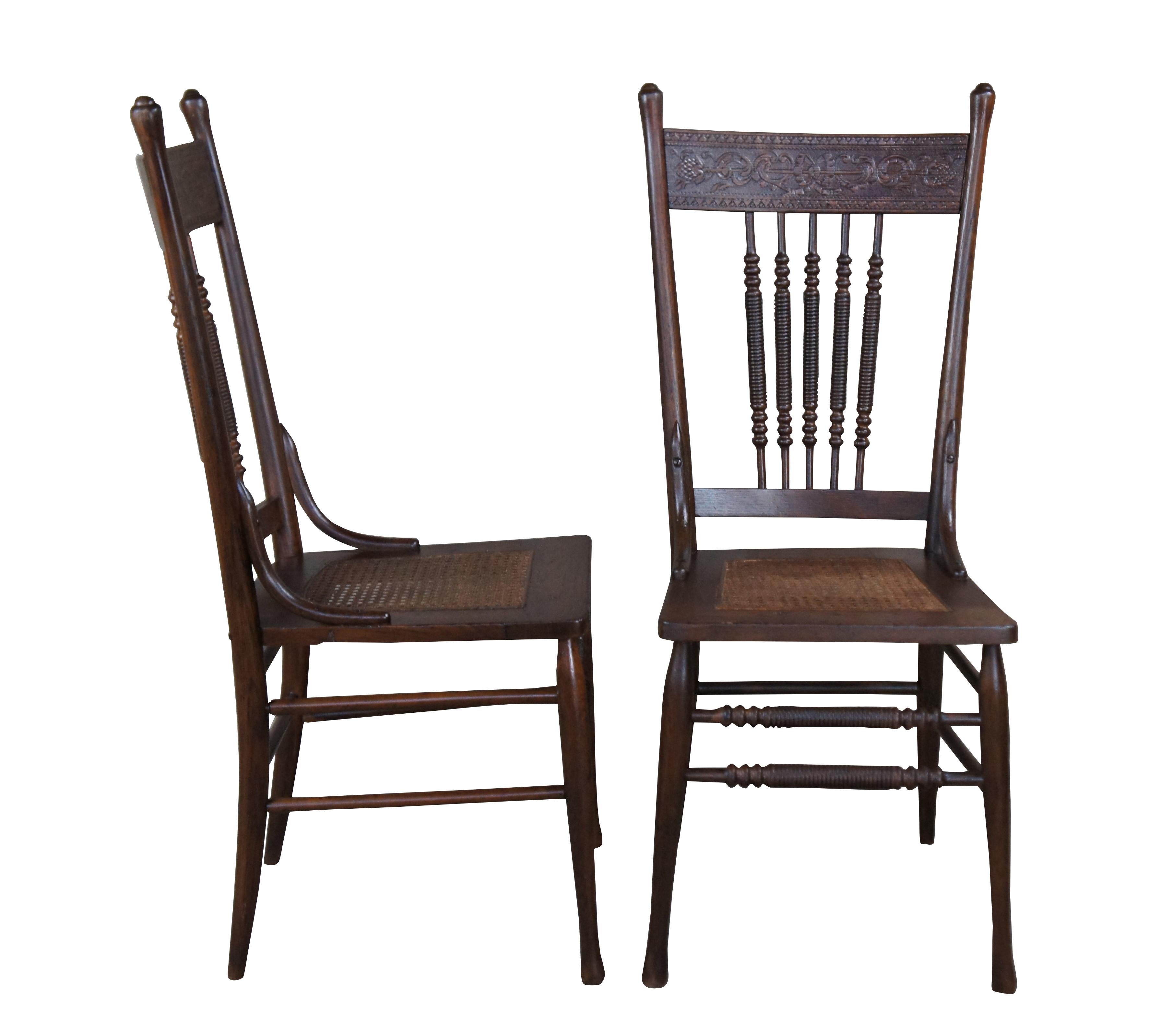 Set of four antique oak chairs with neoclassical pressbacks.  Features ribbed spindle backs, cane seat and slender legs connected by matching stretchers. 

Pressback chairs were popular in the late 1800s and 1900s. Manufacturers engraved patterns