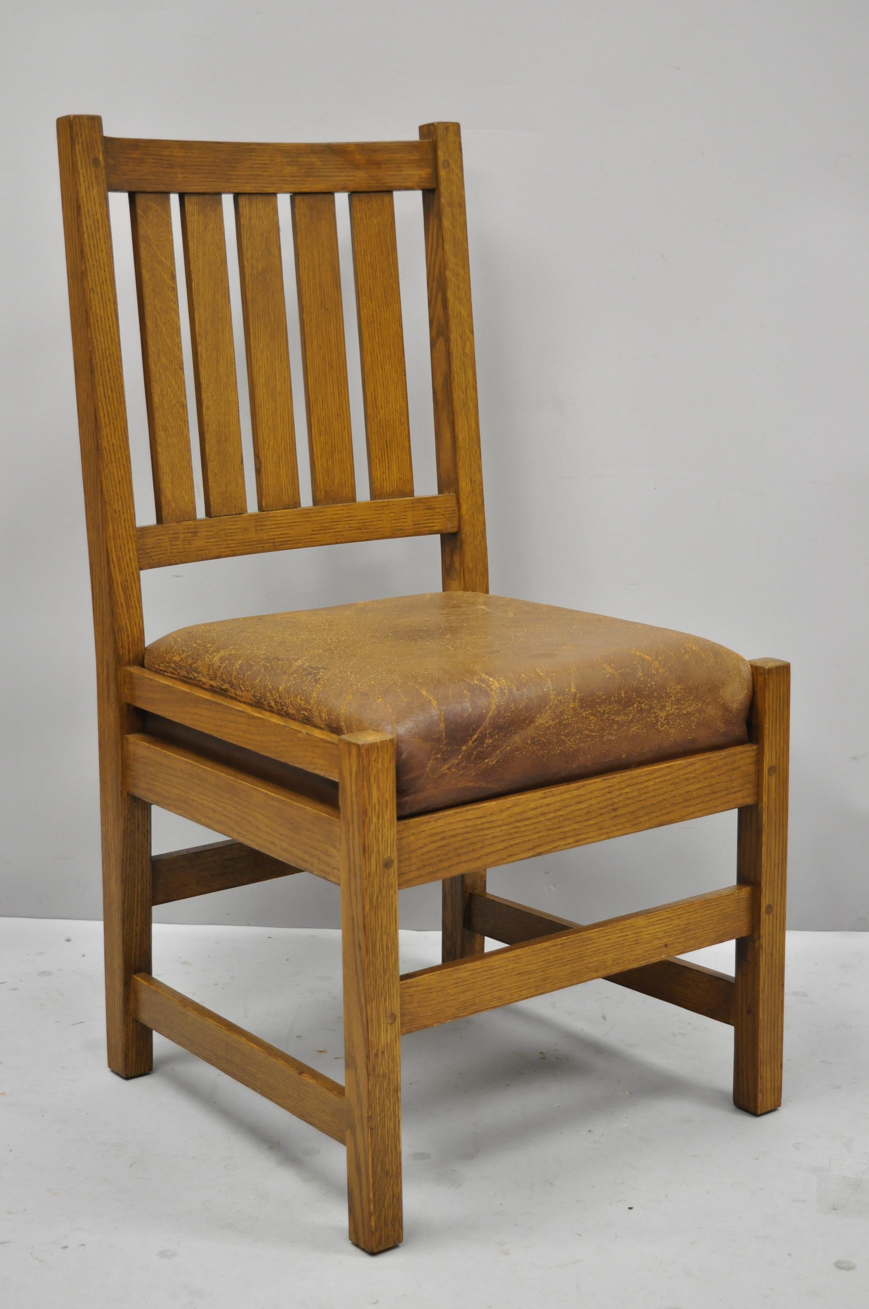 Set of 4 antique mission oak Arts & Crafts Stickley style dining chairs with brown leather seats. Item features slat backs, stretcher base, drop in brown leather seats, solid wood construction, beautiful wood grain, very nice vintage antique item,