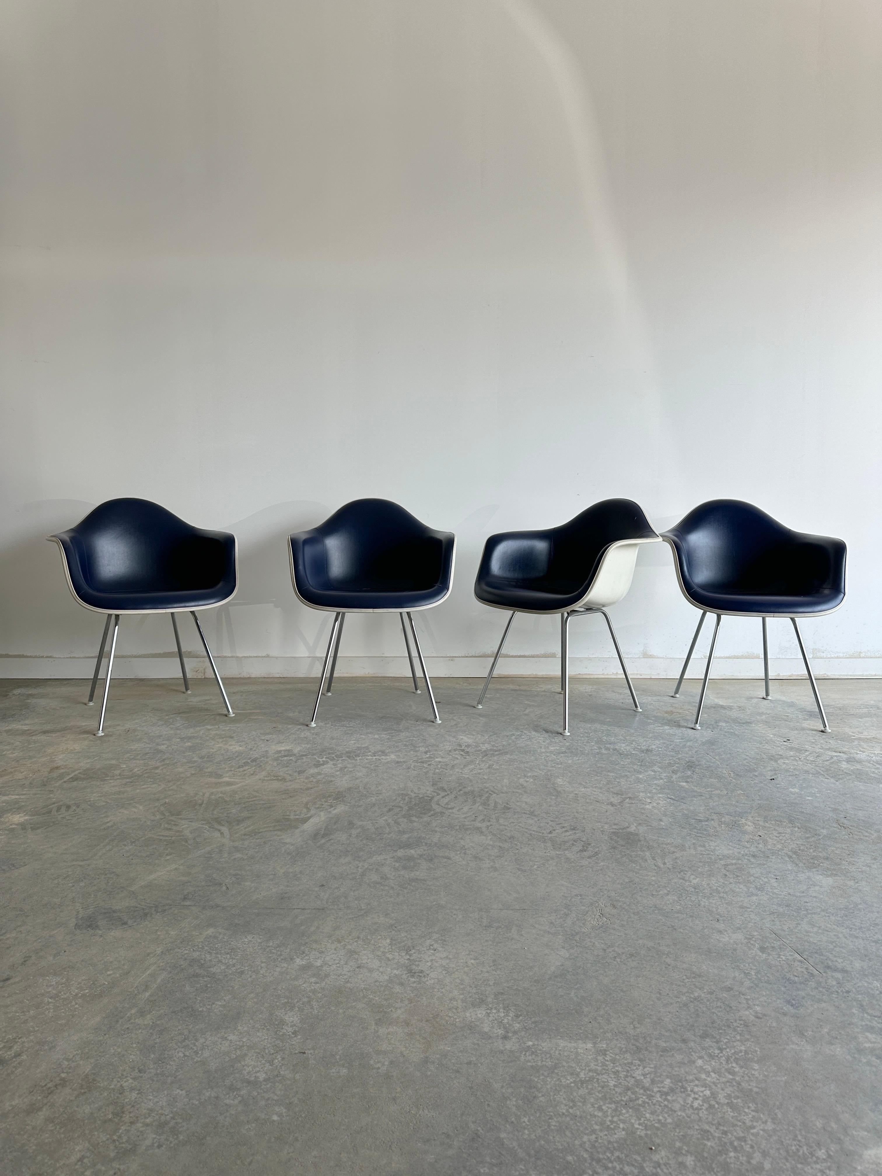 Four blue leather classic rope edge dax armchairs by Charles and Ray Eames for Herman Miller. These chairs were designed in the 1950s by the legendary American couple, who experimented with new materials and techniques to create innovative and