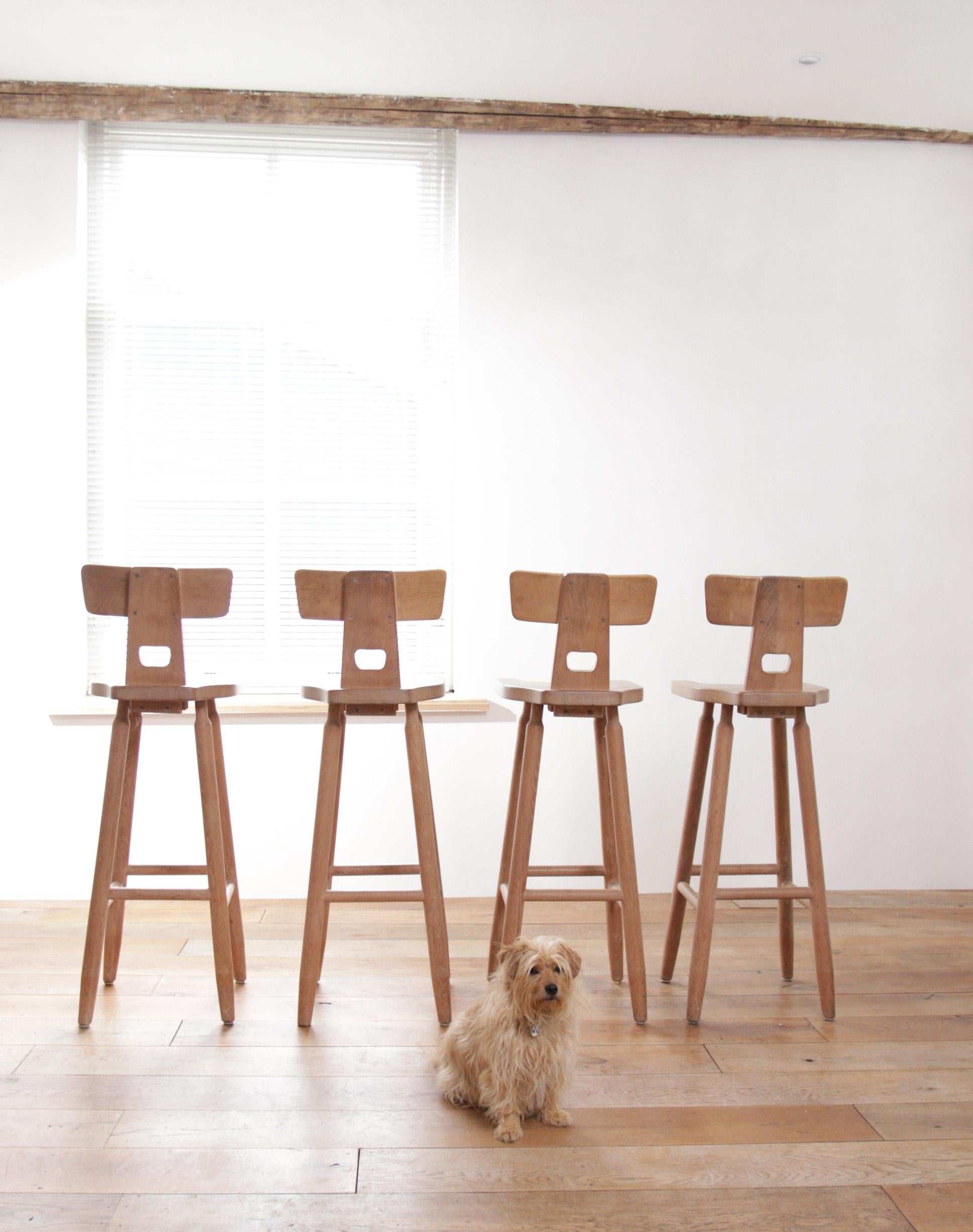 Crafted from solid oak in the 1970s, these four barstools are a testament to the enduring quality of vintage furniture.

Featuring a distinctive hammerhead back design, these barstools exude a sense of sophistication and charm. The gently curved top
