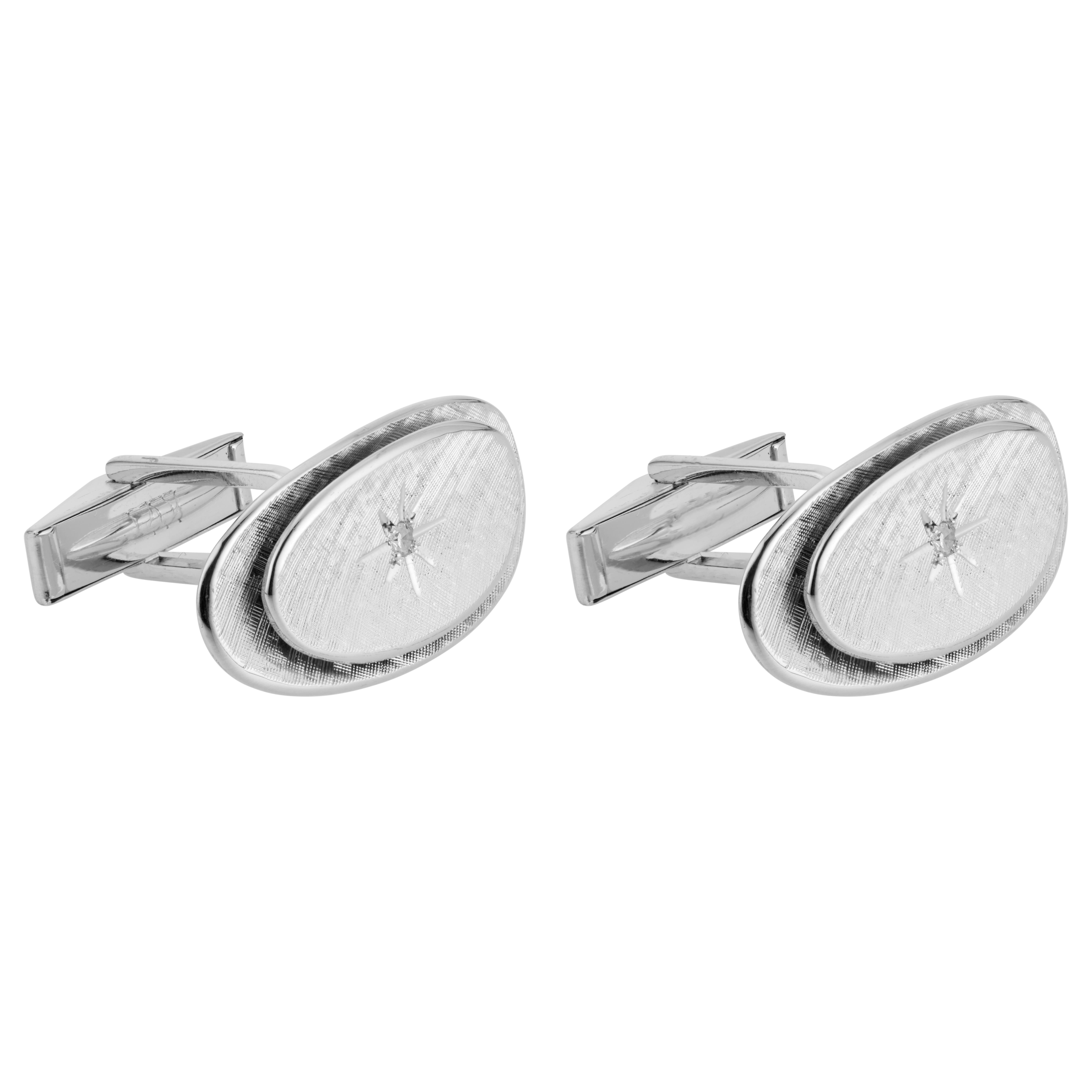 Vintage 1950's 14k white gold cufflinks with two concave oval sections, one above the other. Both have a hand Florentine finish, each with a star design in the middle with diamonds accents. 

2 single cut diamonds, I SI approx. .4cts
14k white gold