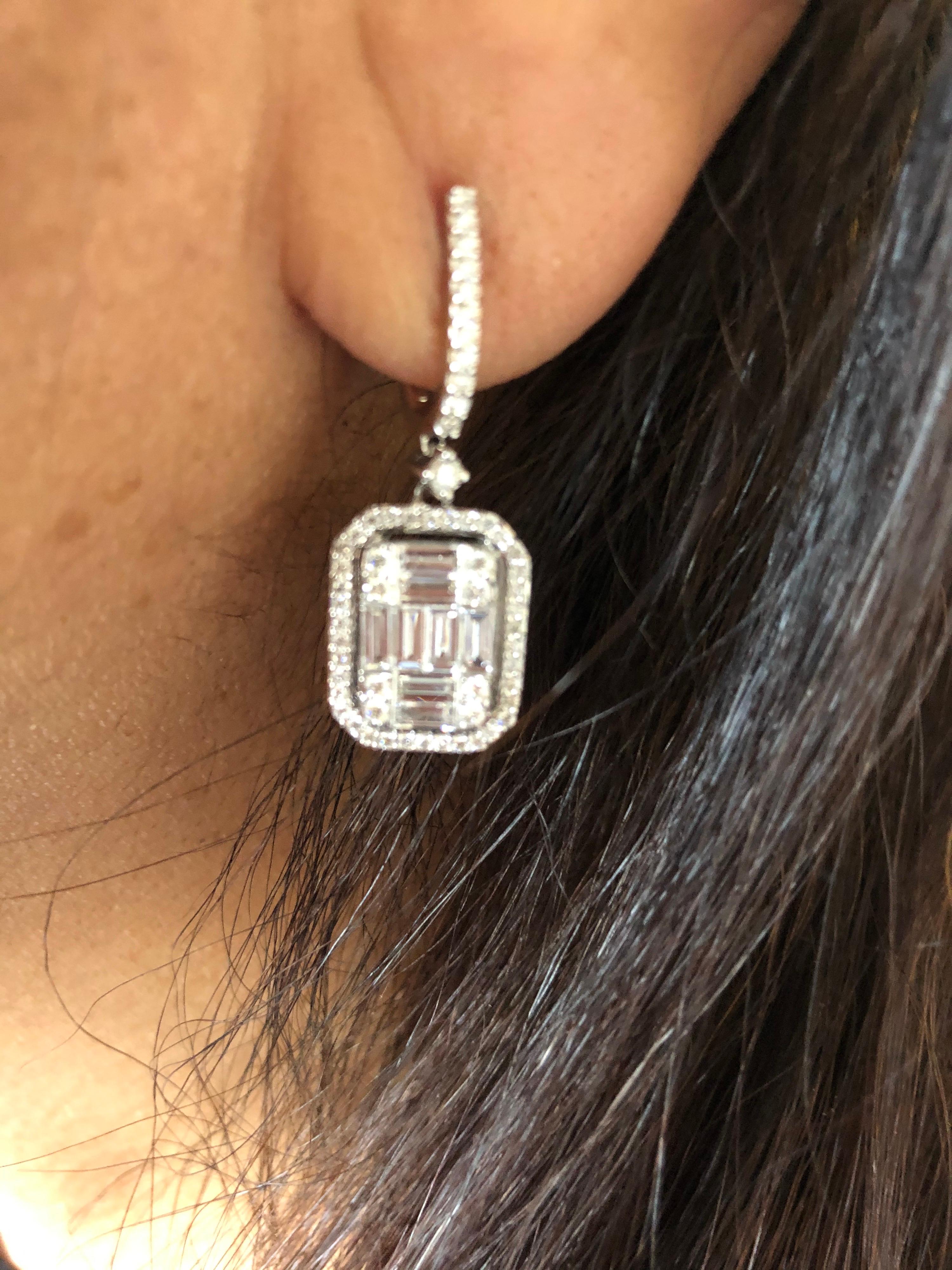 Emerald Cut diamond illusion earrings set in 18K white gold. These earrings are set with a cluster of baguette and round diamonds that create the illusion of a single emerald cut stone. The total weight of the earrings is 3.87 carats. The color of