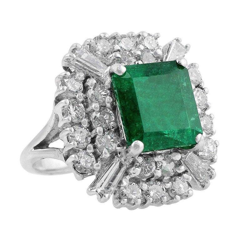 Dieser atemberaubende Smaragd- und Diamantring ist aus 14 Karat Weißgold gefertigt:: mit einem zentralen Smaragd besetzt und von 28 Diamanten mit einem Gewicht von ca. 1::92cttw umgeben. Der Smaragd wiegt 4::42 Karat und misst 9::96 x 9::65 x 6::91