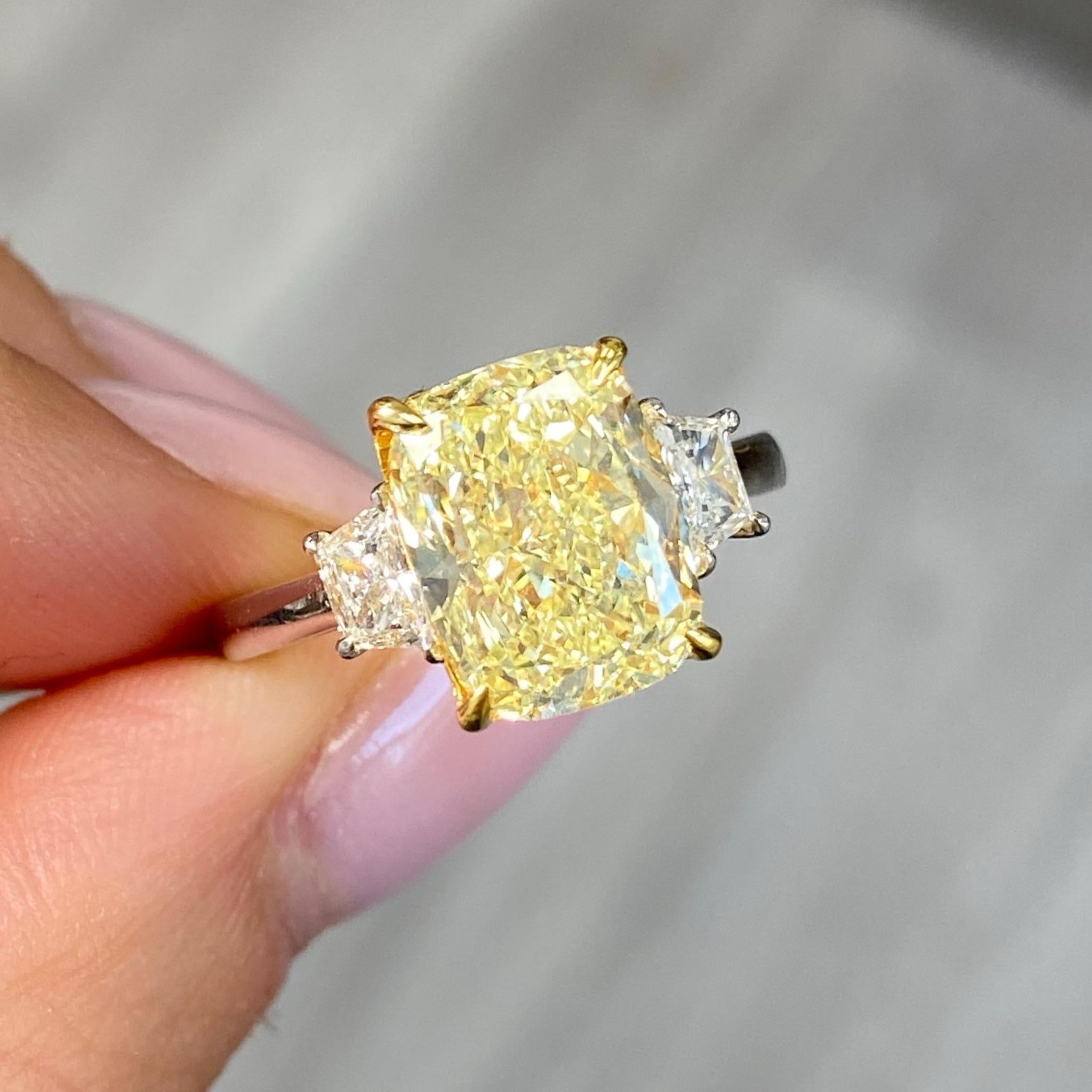 Abbraccia la bellezza della rarità con il nostro anello a tre pietre con diamante a cuscino allungato giallo da 4 carati, un pezzo sofisticato realizzato per affascinare. Il cuore è un diamante giallo di 4 carati certificato GIA con purezza VS1, che