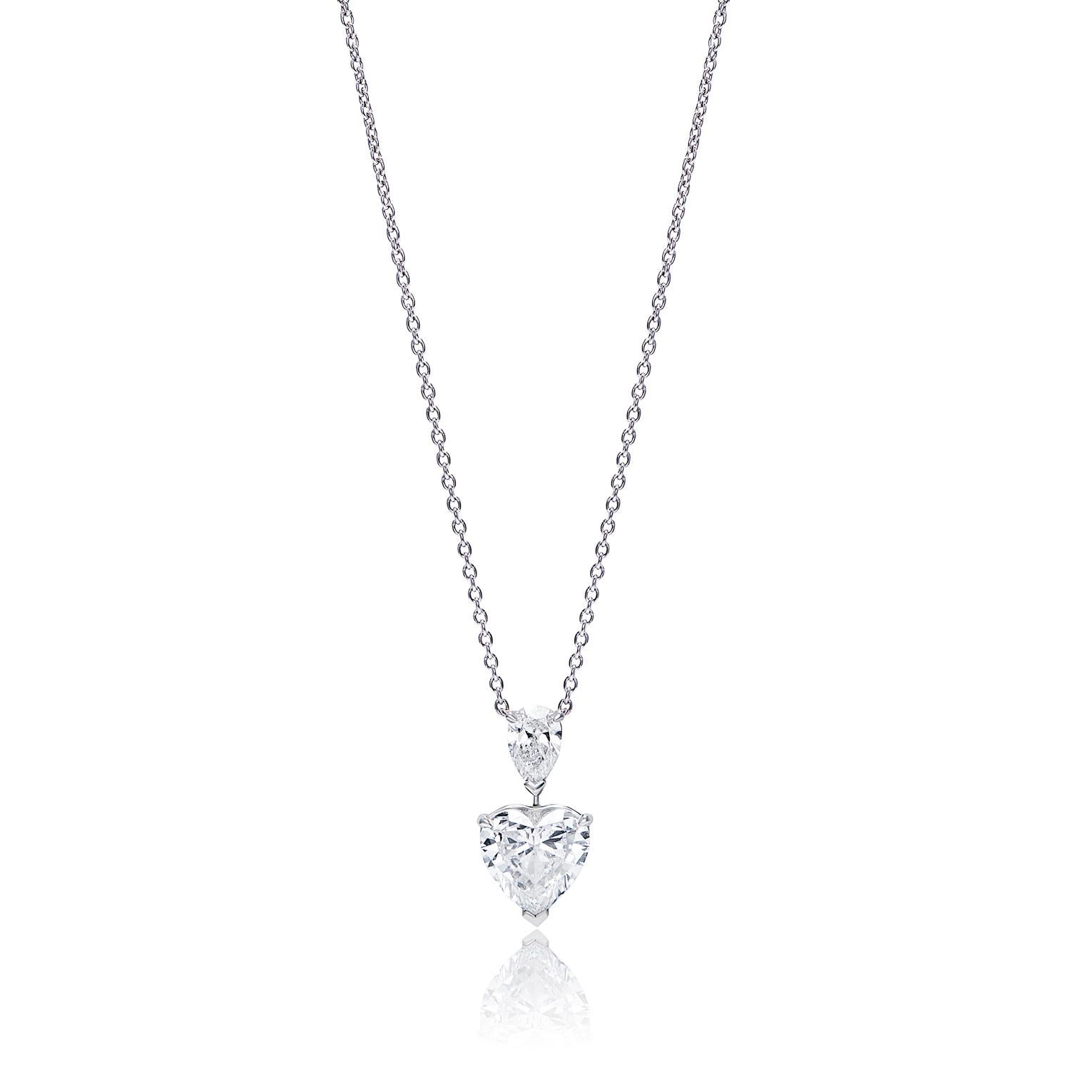 This gorgeous pendant features a 3.25 carat D VS1 diamond, set in a beautiful heart shape. The upper diamond is a 0.52 carat D SI1, set in a pear shape. These diamonds are set in platinum chains and make the perfect addition to any outfit. Whether