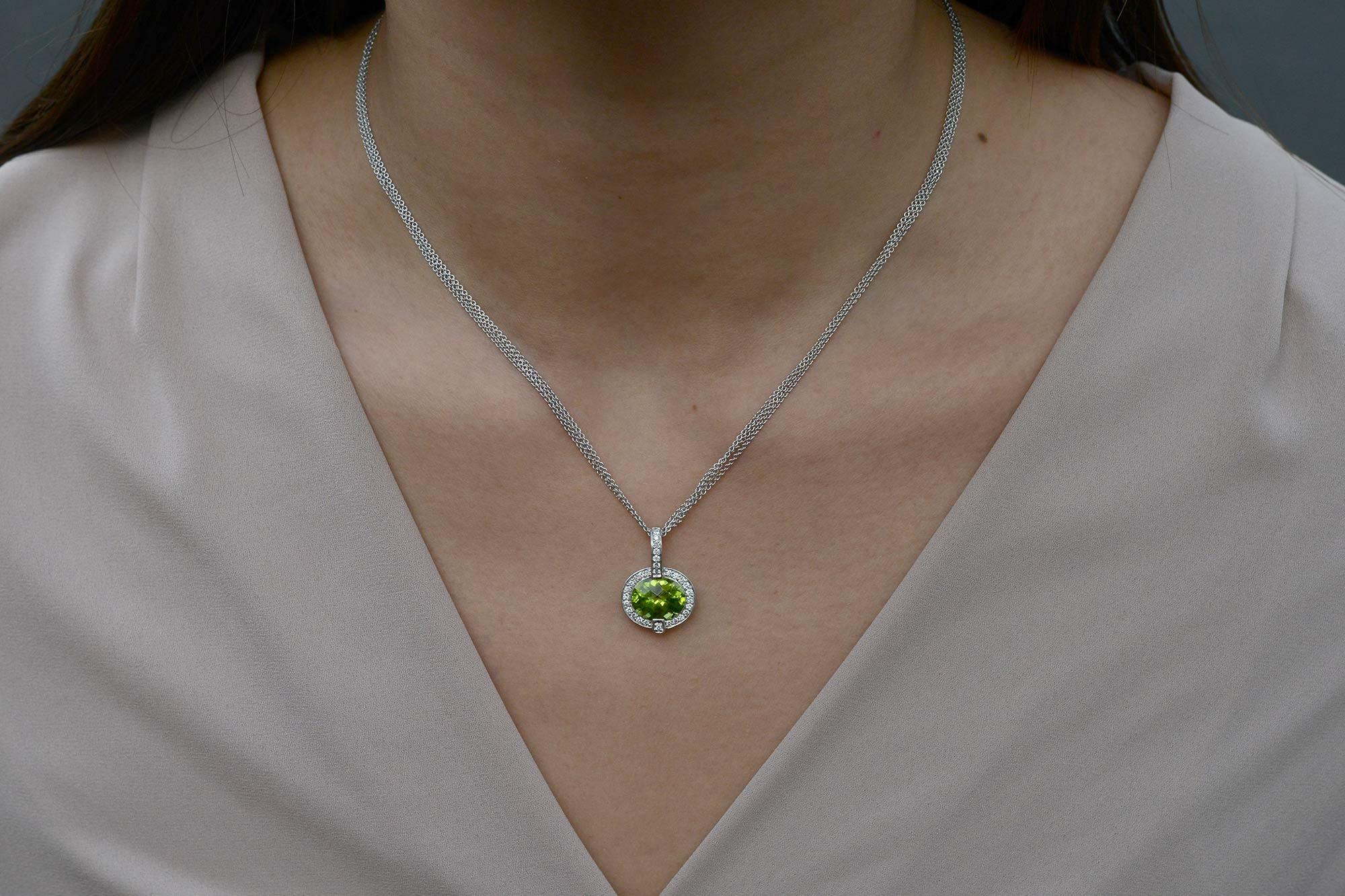 This show stopping necklace parades the finest quality intense green peridot oriented in an unusual east to west setting. The striking gemstone pendant is encircled by a luminous diamond frame seductively suspended by sleek 18k white gold strands. A