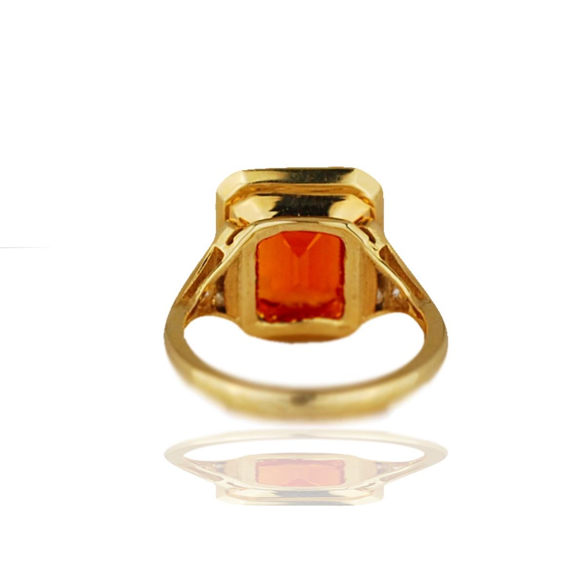 A stunning 4 carat emerald cut sits center in this orange sapphire (man-made) and diamond ring.  The center sapphire is a natural orange sapphire with a bright tangerine color.  The sapphire has a wonderful clarity and has great luster to the stone