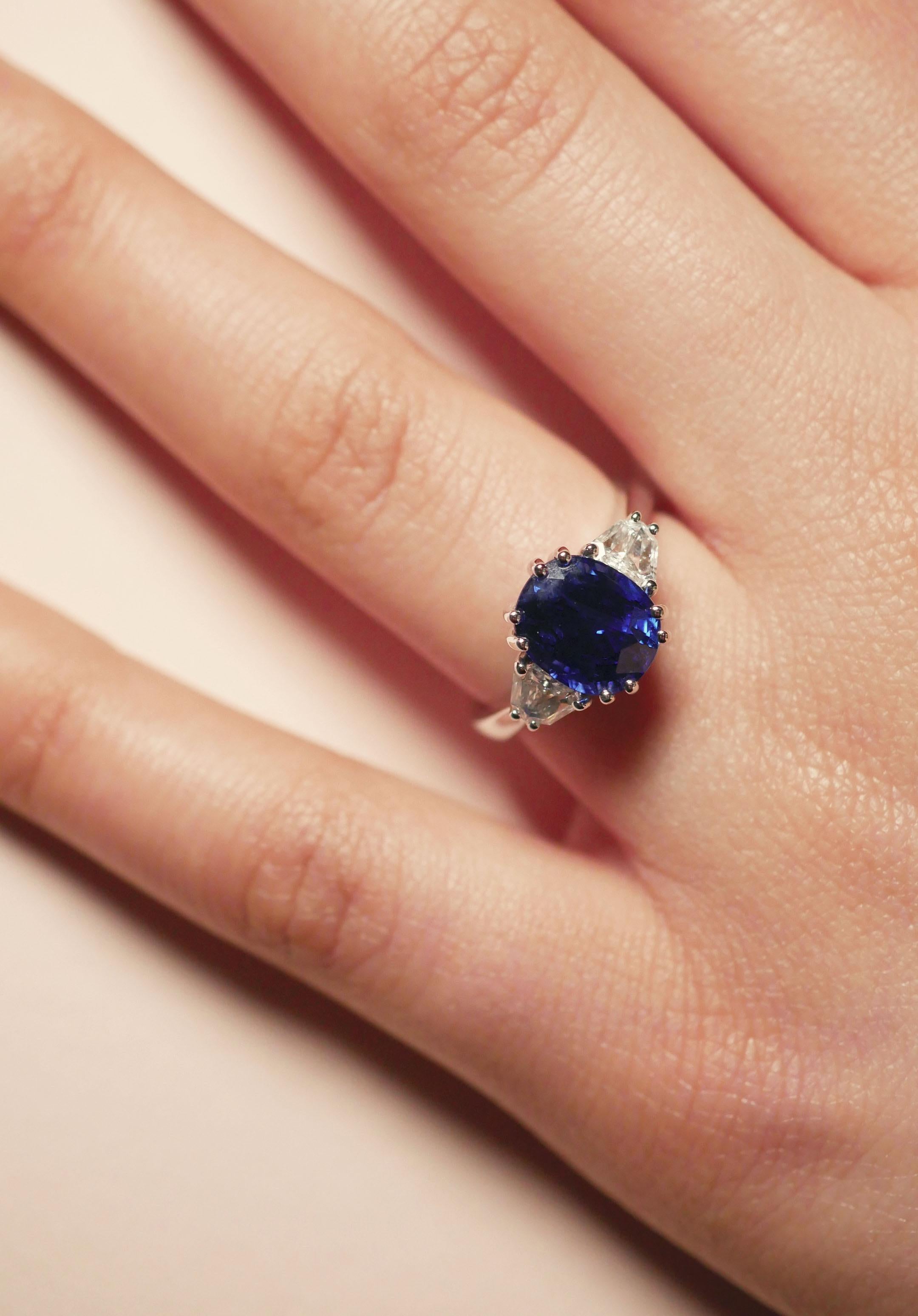 A sleek three-stone 18k white gold ring with a 4 carat deep blue sapphire at its centre beautifully set with four-double smooth claws, and two dazzling tapered diamond baguettes at each side.

Ring Size: UK - N, US - 7
0.48 Carat Diamonds