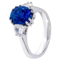 Bague à trois pierres en or blanc avec saphir bleu ovale de 4 carats