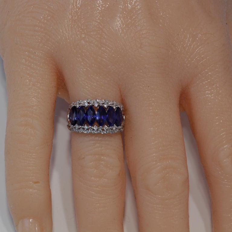 This beautiful band has six oval cut blue sapphires totaling 4.0 carats, among 0.36 carats round white diamonds. Delicate design work throughout the 18k White Gold band, including a raised under gallery, make this piece a gorgeous addition to your