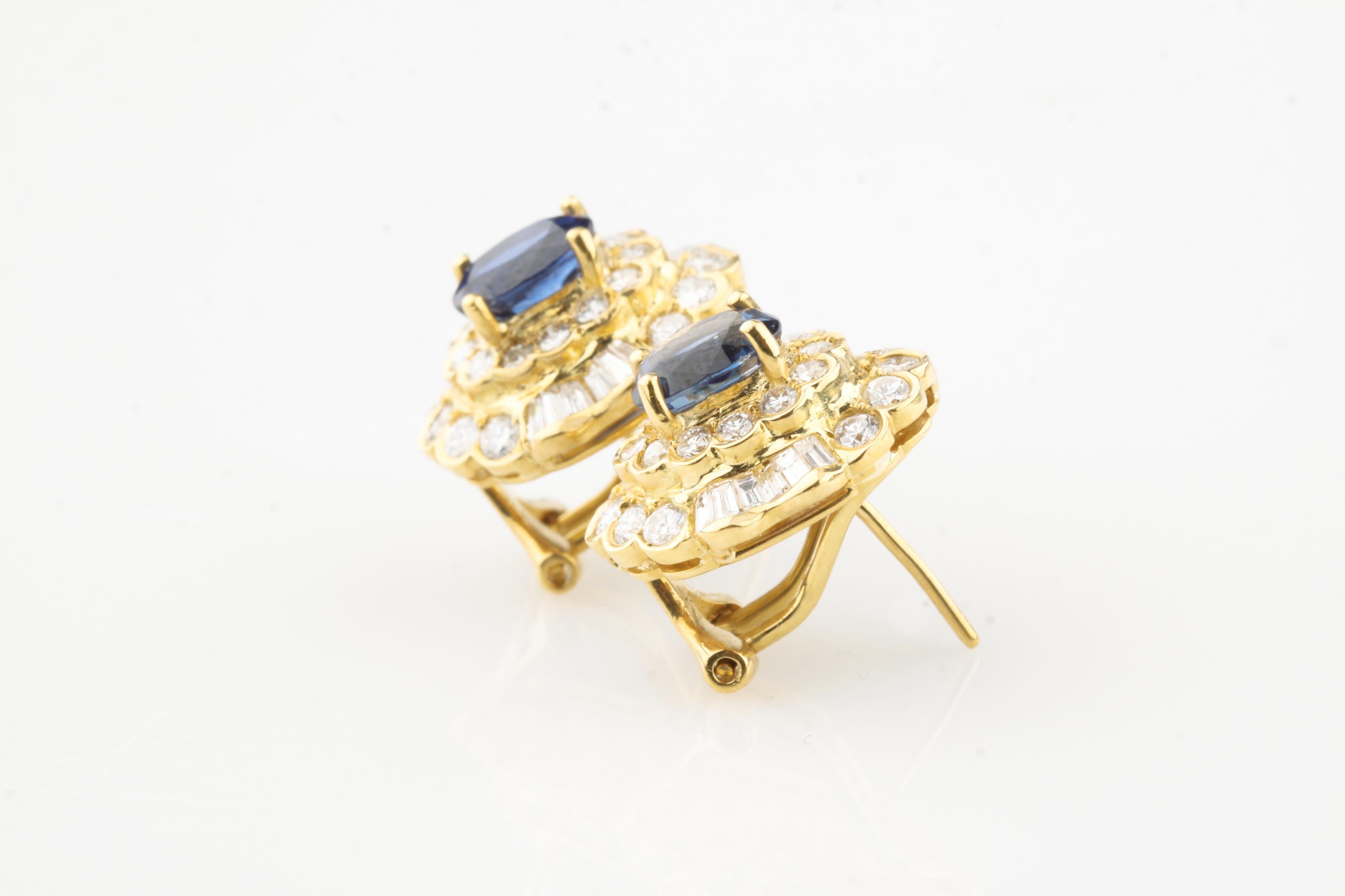 Beautiful Sapphire Huggie Earrings in 18k Yellow Gold
Feature Gorgeous Prong-Set Oval Sapphire Solitaires
Total Sapphire Weight = Appx 2 Cts
Surrounded by Double-Bezel of Bezel-Set Round and Channel Baguette Diamonds
Semi-Ballerina Setting
Total
