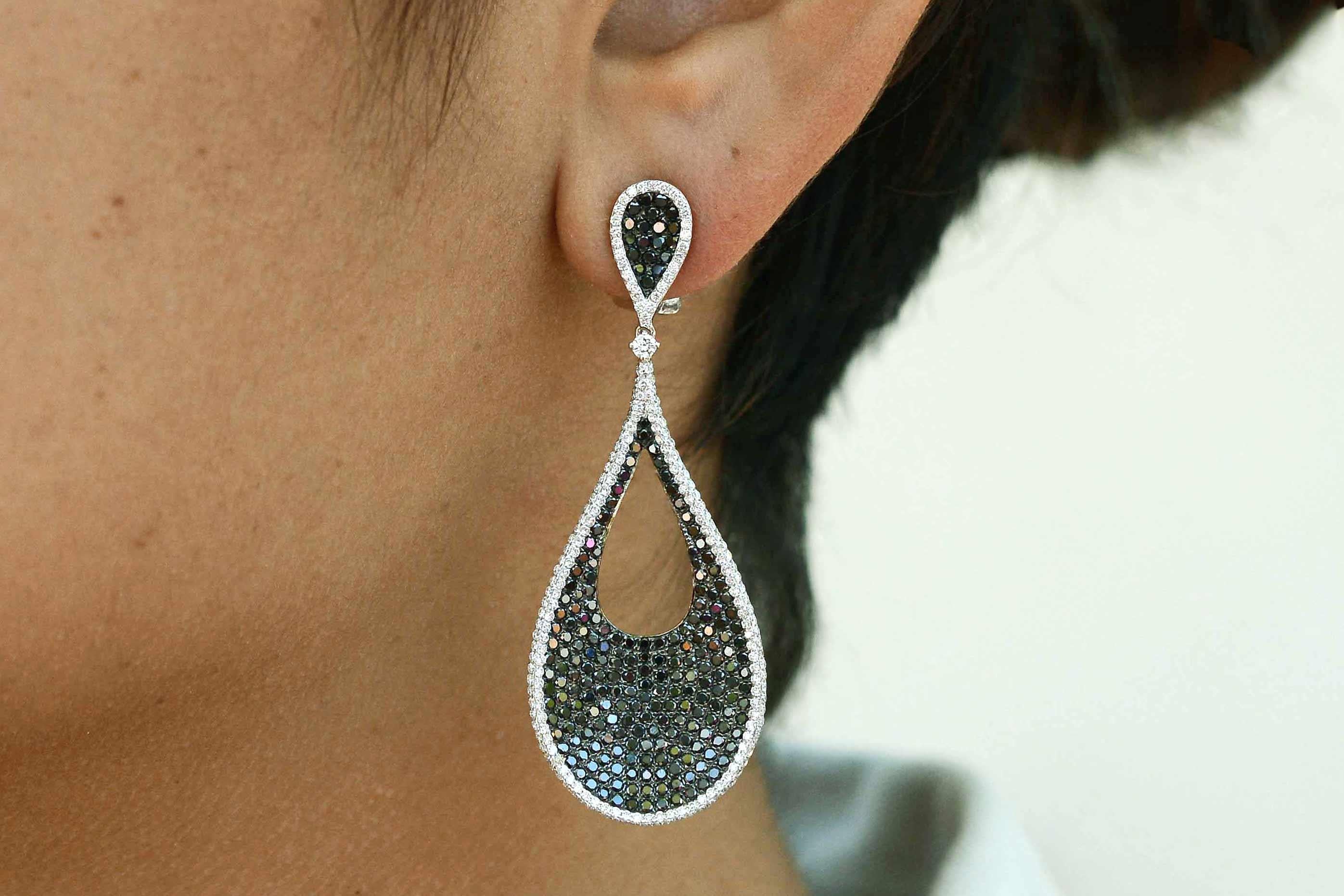 Ein verlockendes Paar schwarzer und weißer Diamant-Ohrringe mit dramatischem Flair. Der zweiteilige Tropfenohrring mit einer faszinierenden Tropfenform und konkaver Textur ist mit fast 4 Karat Diamanten besetzt. Mit einer Länge von über 1,5 cm
