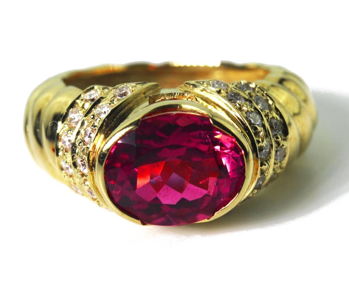 Sparkling  deep 4 carat oval pinky red Brasilian natural Tourmaline enhanced with small sparkling brilliant white diamonds set in a unique handmade 18 Karat yellow gold ring size  7 (sizable for free). 