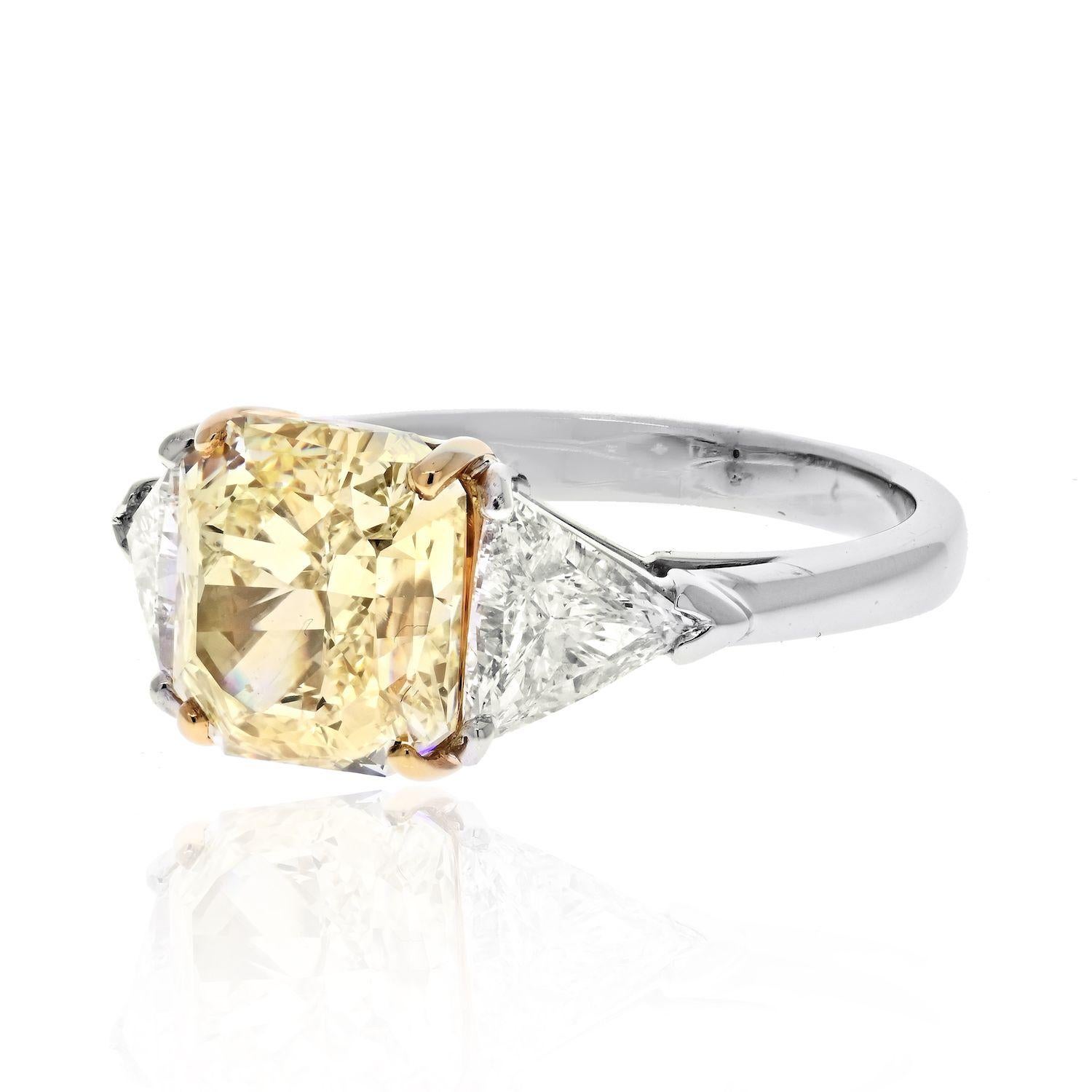 This marvel of a jewel features three natural diamonds. 

Centering a glorious Fancy Yellow Radiant cut diamond of 4.13 cts this is a flawless (and we mean it!) certified canary diamond. 

Flanked by (2) trilliant cut diamonds of 1.08 cttw this ring