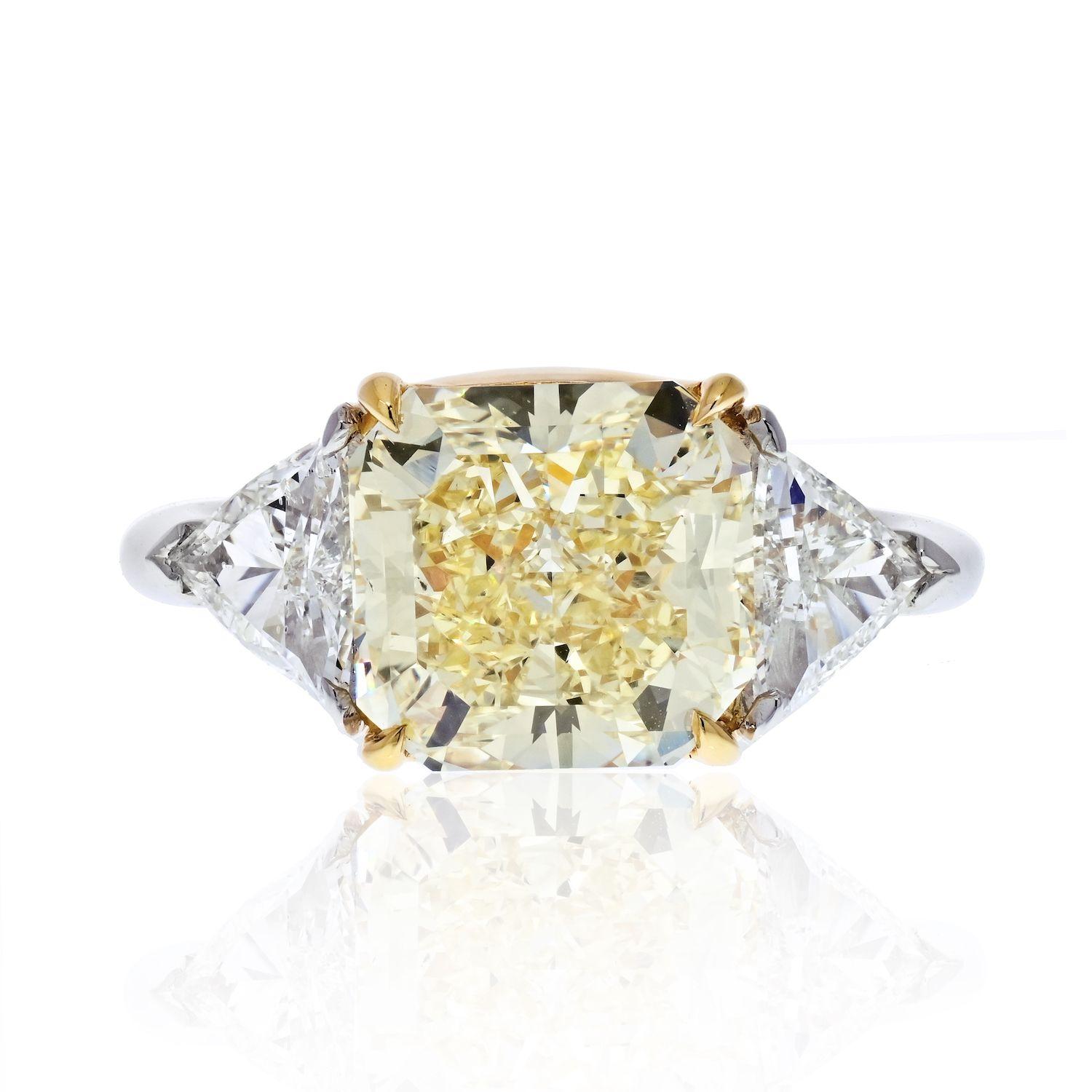 This is a beautiful three-stone diamond engagement ring crafted in Platinum set with a GIA certified four-carat radiant cut diamond. 

Center diamond is a 4.78 carat center diamond, radiant shape, this diamond is of a natural fancy yellow color and