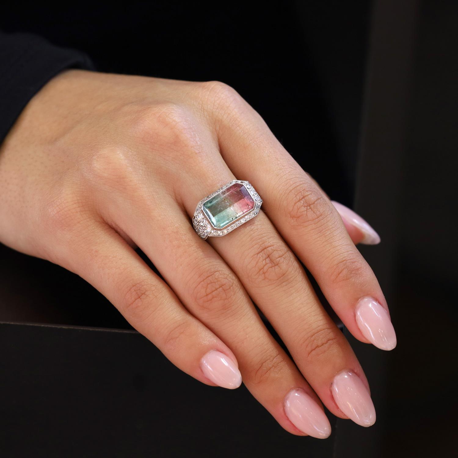 Questo delizioso anello con tormalina anguria presenta una gemma piuttosto rara. Un impressionante esemplare di gemma di 4,61 carati con taglio smeraldo che presenta tonalità verdi e rosa bluastre causate da tracce di ferro e forse titanio e