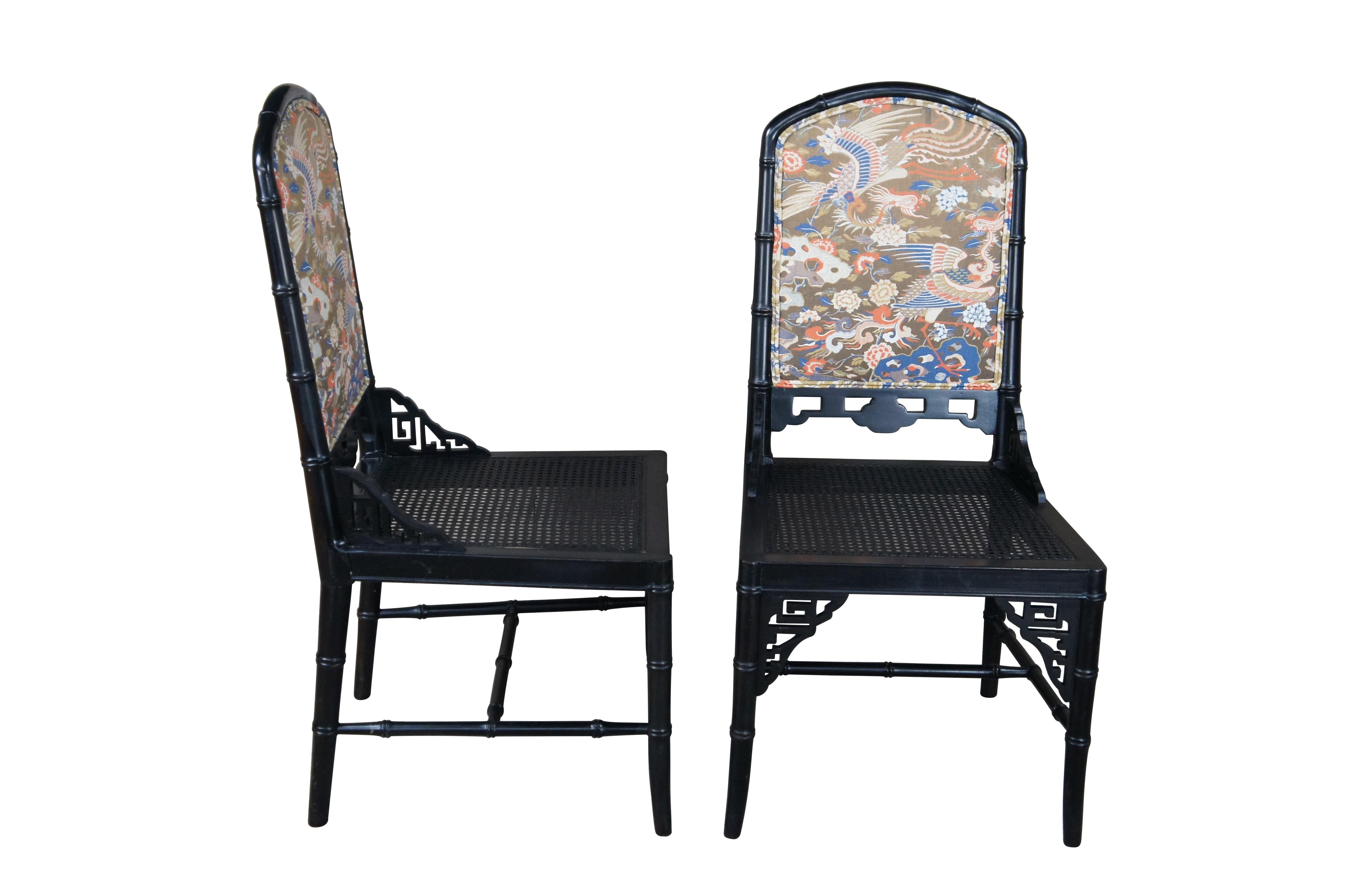Four mid century faux bamboo caned dining chairs featuring black lacquered finish with reticulated accents and Crane theme upholstery.

Dimensions:
19.5