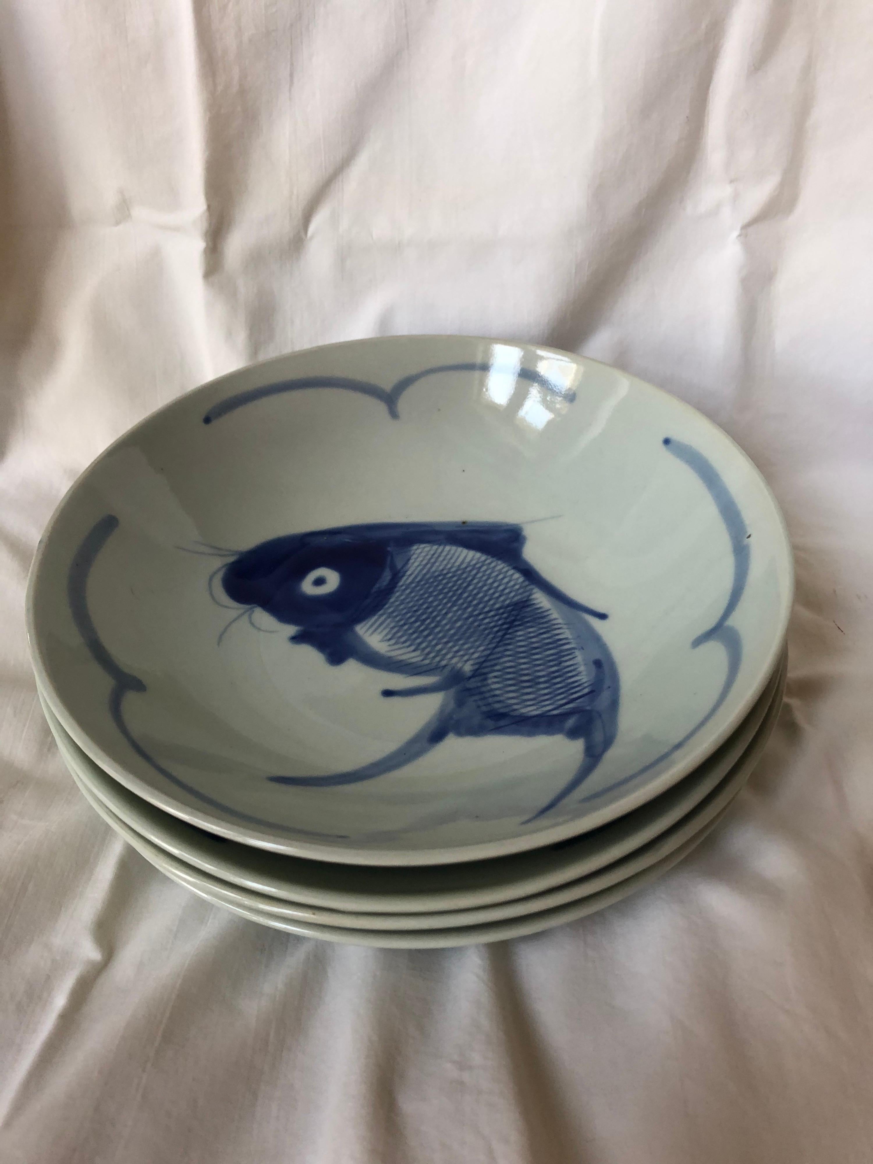 Wonderful set of four good sized pale blue Chinese vintage porcelain soup plates with cobalt blue decoration of koi or carp. Grew up loving these! Modern but ancient design.