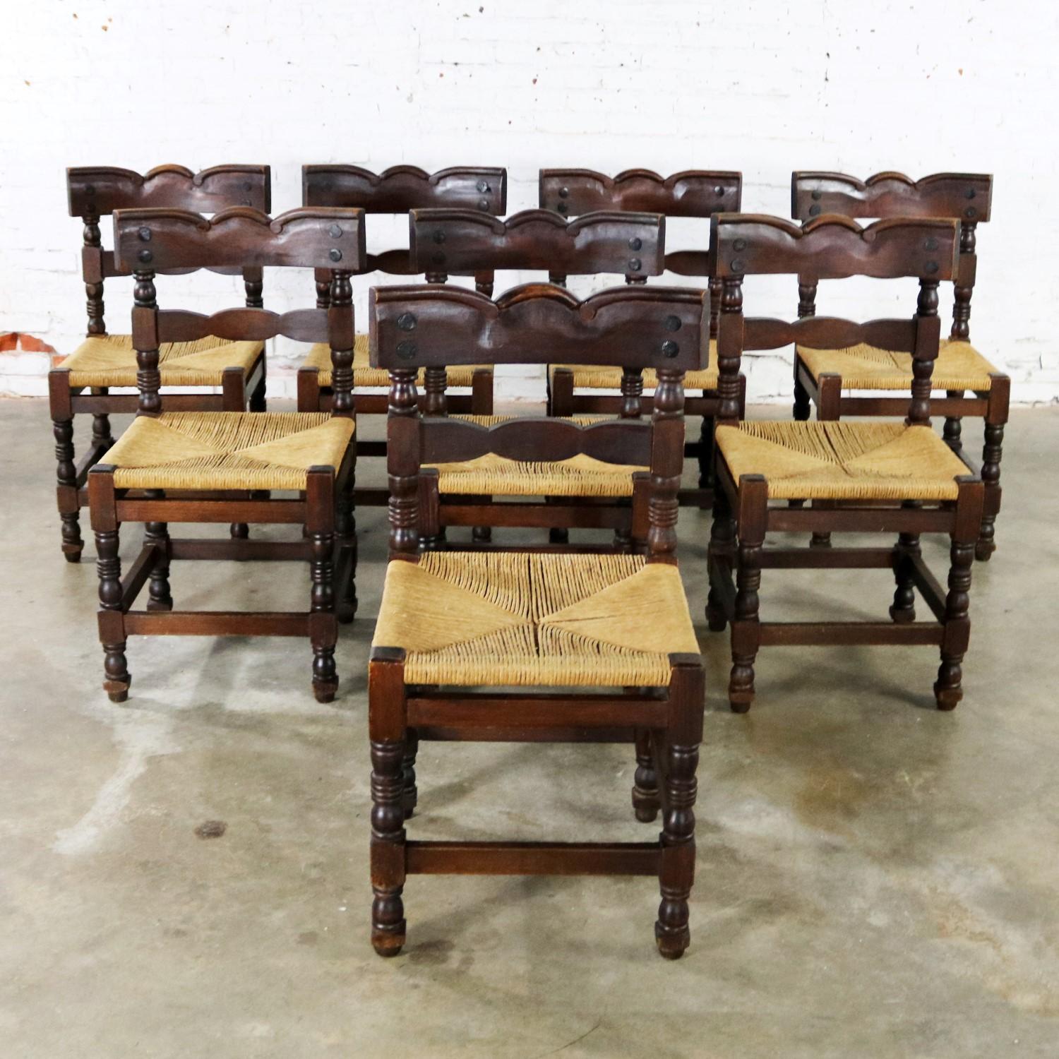 Handsome Spanish Colonial or Spanish Revival style dining chairs with natural rush seats and large nailhead detail. Stamped with a black oval marking with Hecho en Mexico. They are in wonderful vintage condition with lots of beautiful age patina