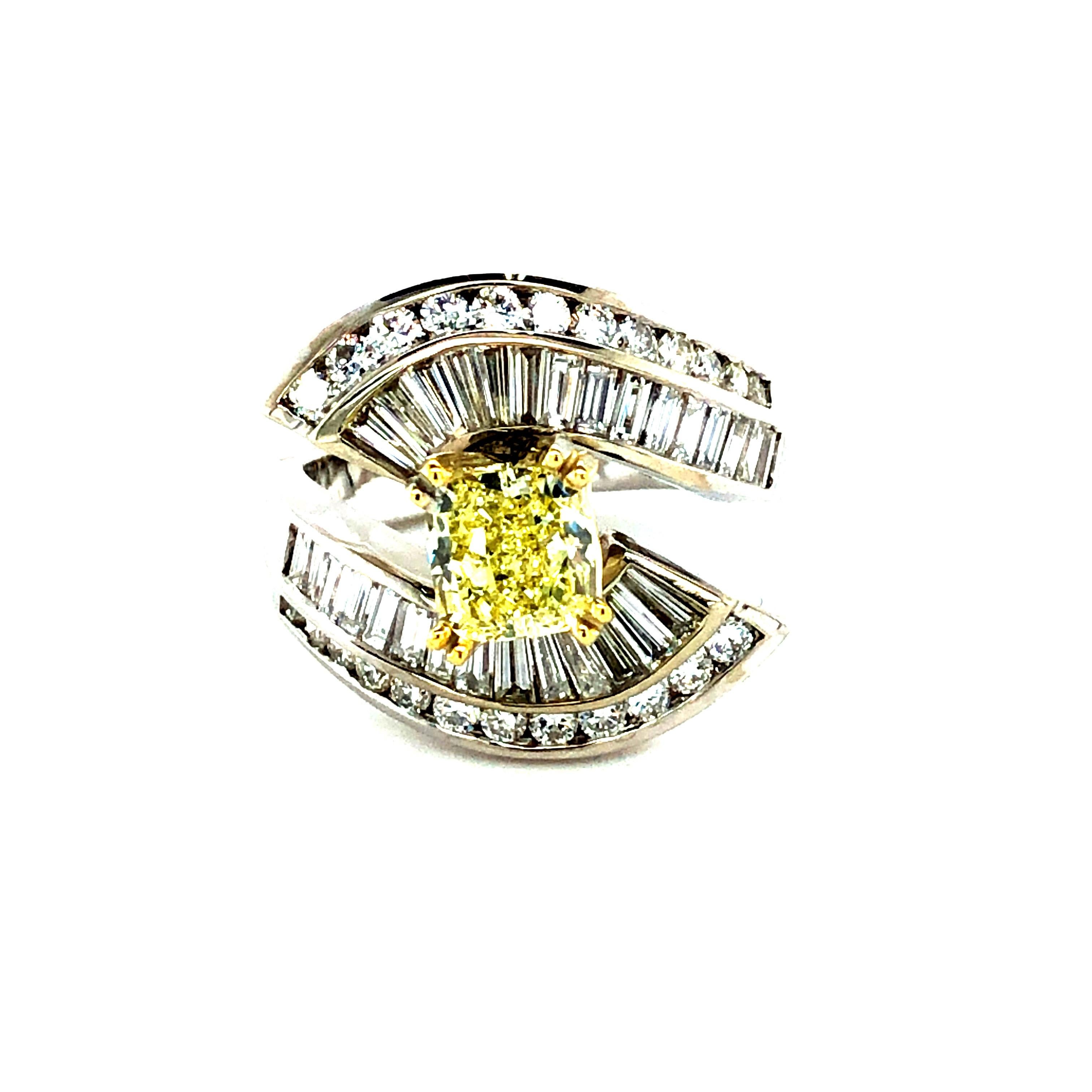 Offered here is an elegant engagement ring circa 1980, made i solid 18kt white gold shank and yellow gold 4 prong setting.
Featuring one natural earth mined G.I.A certified fancy yellow diamond weighing 1.25 ct set in a cascade of white natural