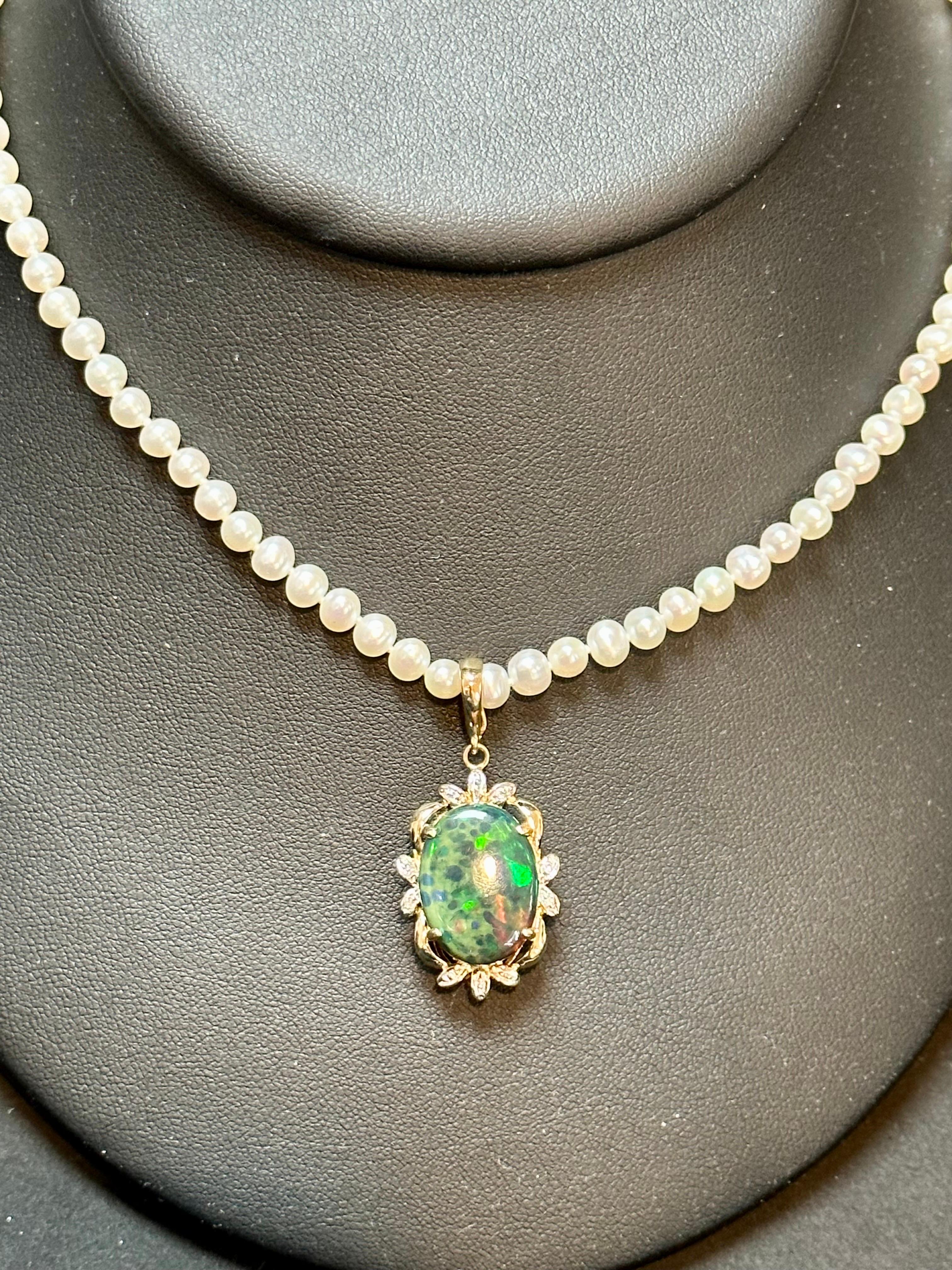 Introducing our exquisite 14K Yellow Gold Pearl Necklace featuring a captivating 4 Carat Oval Black Australian Opal surrounded by dazzling diamonds. The opal displays a mesmerizing play of green, blue, and red hues, emanating a brilliant luster and