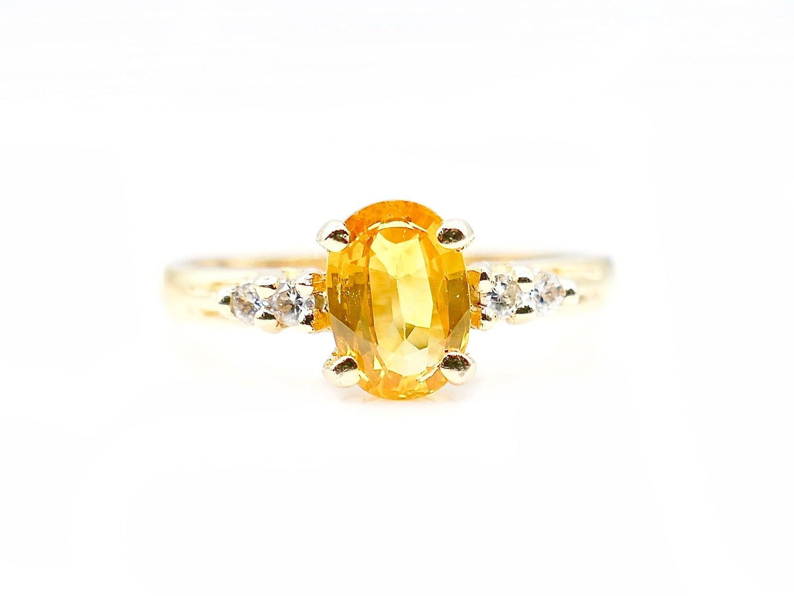 This lovely and delicate Yellow Sapphire ring is a classic piece that could be used as an engagement ring (for those couples that prefer a unique allure). The prong-set, oval Yellow Sapphire weighs in at approximately 1 Carats total and has 2 small