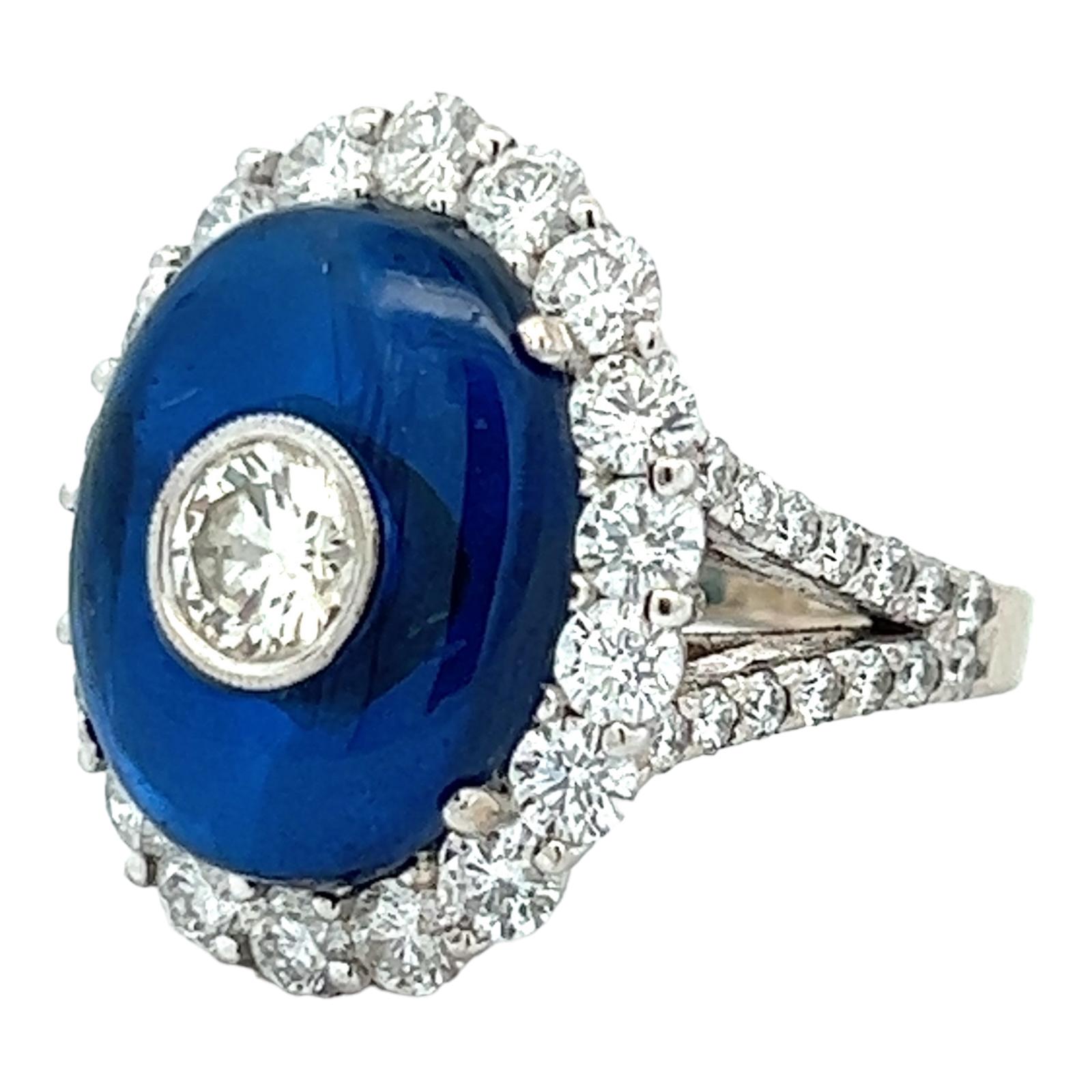 Stunning Art Deco style bezel set diamond and blue spinel cocktail ring. The ring features a bezel set .62 carat round brilliant cut diamond (K/SI) surrounded by a beautiful blue spinel cabochon gemstone. The mounting features approximately 3.50 CTW