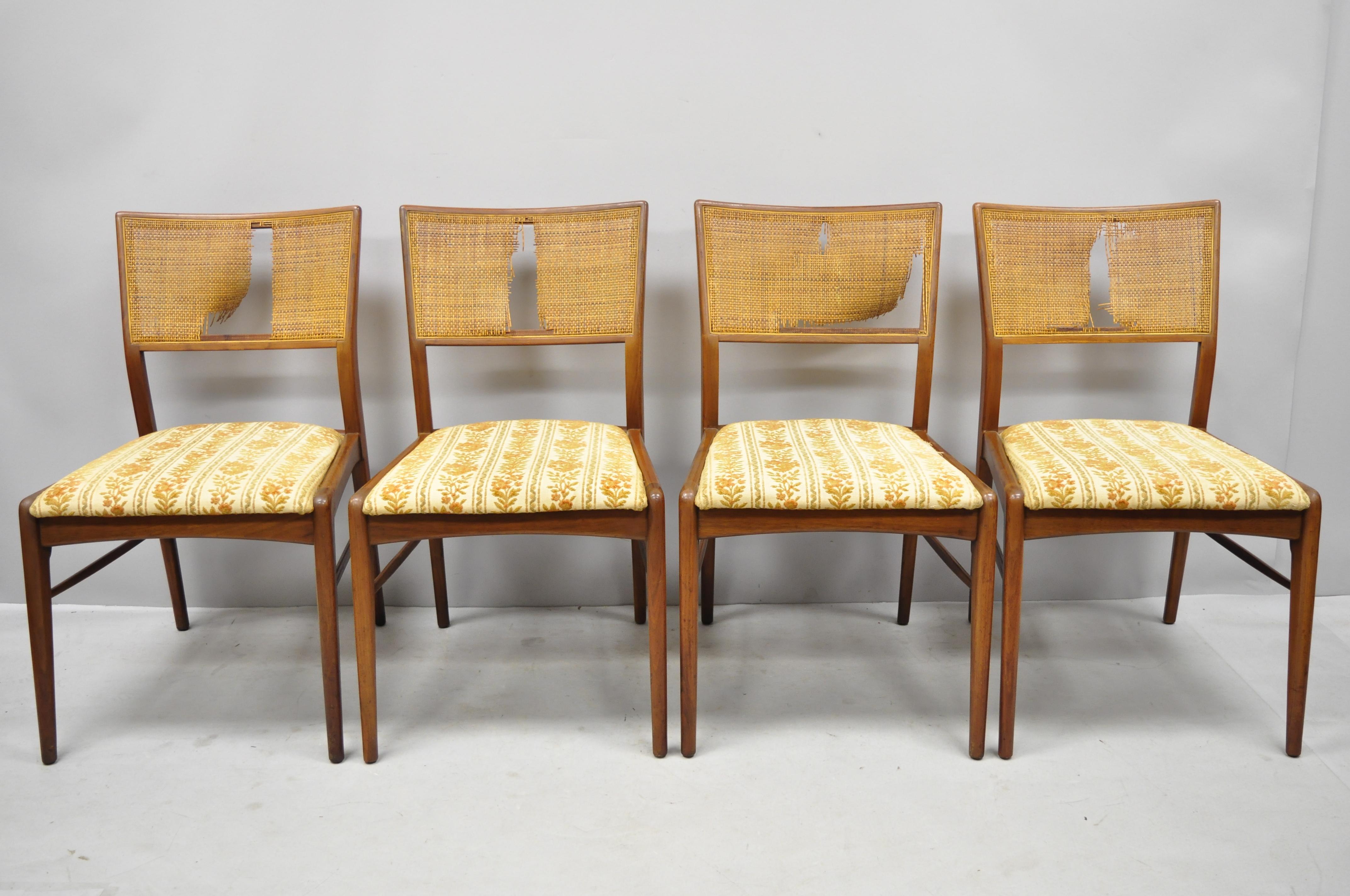 4 Danish Mid-Century Modern walnut cane back dining chairs after TH Robsjohn Gibbings. Items feature cane backs, solid wood construction, beautiful wood grain, upholstered seat, tapered legs, sleek sculptural, circa 1960. Measurements: 32