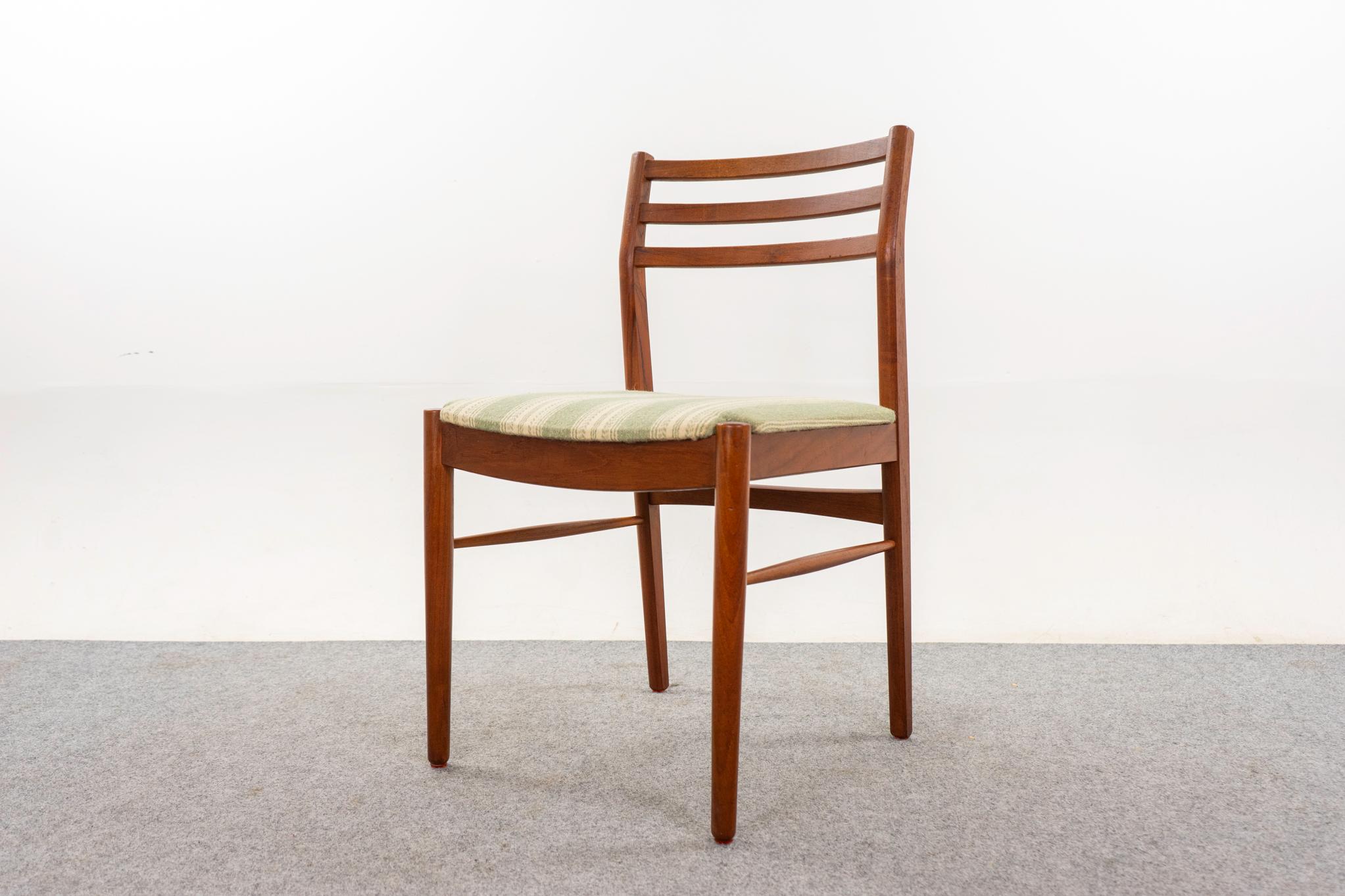 Teak mid-century dining chairs, circa 1960's. Beautifully curved ladder backrests and generous seat. Solid wood frame with cross braces for added stability and support. Original fabric in nice condition, removable seat pad makes reupholstering a