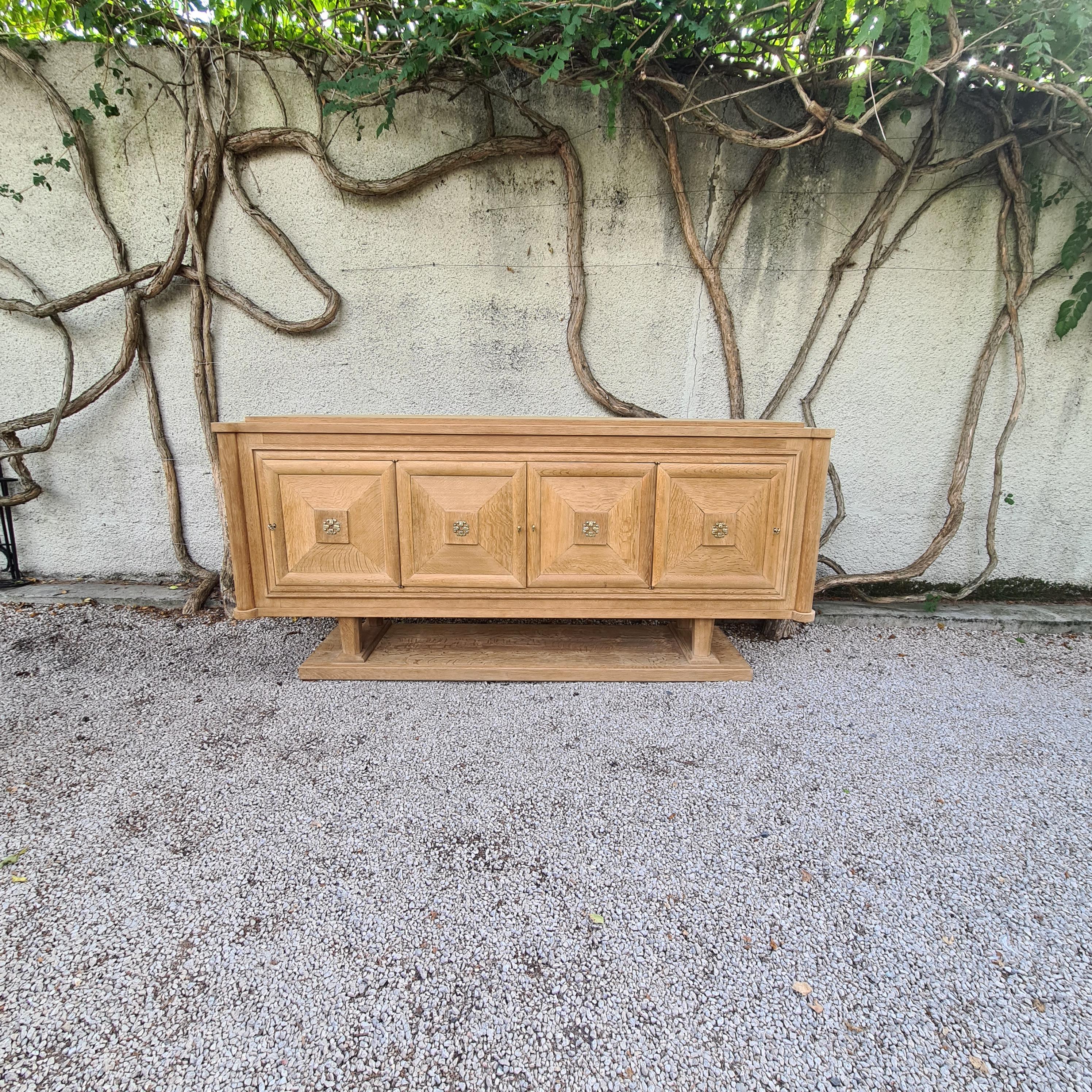 Magnificent art deco sideboard circa 1930, consists of 4 inverted opening doors, 2 central drawers. Door details, keyholes and finishes are in brass. Nice honey-coloured patina, some minimal traces of wear and tear on the top, an incredible art deco