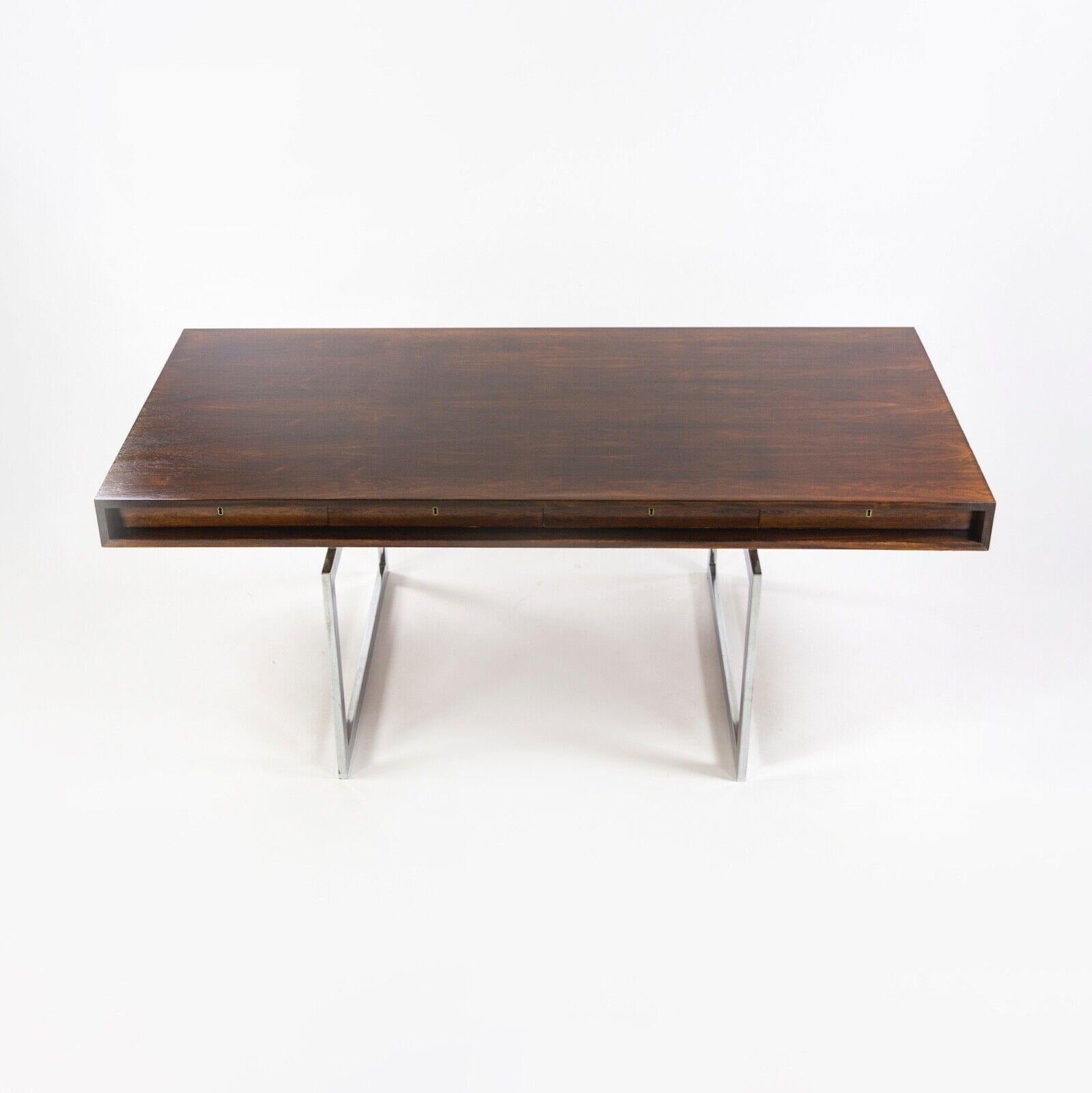 Ti presentiamo un bellissimo esempio di scrivania a 4 cassetti di Bodil Kjaer per E. Pedersen & Son, rifinita in palissandro brasiliano. Il tavolo è stato oliato di fresco. Ci sono alcuni segni di usura dovuti agli ultimi 50-60 anni di utilizzo. Si